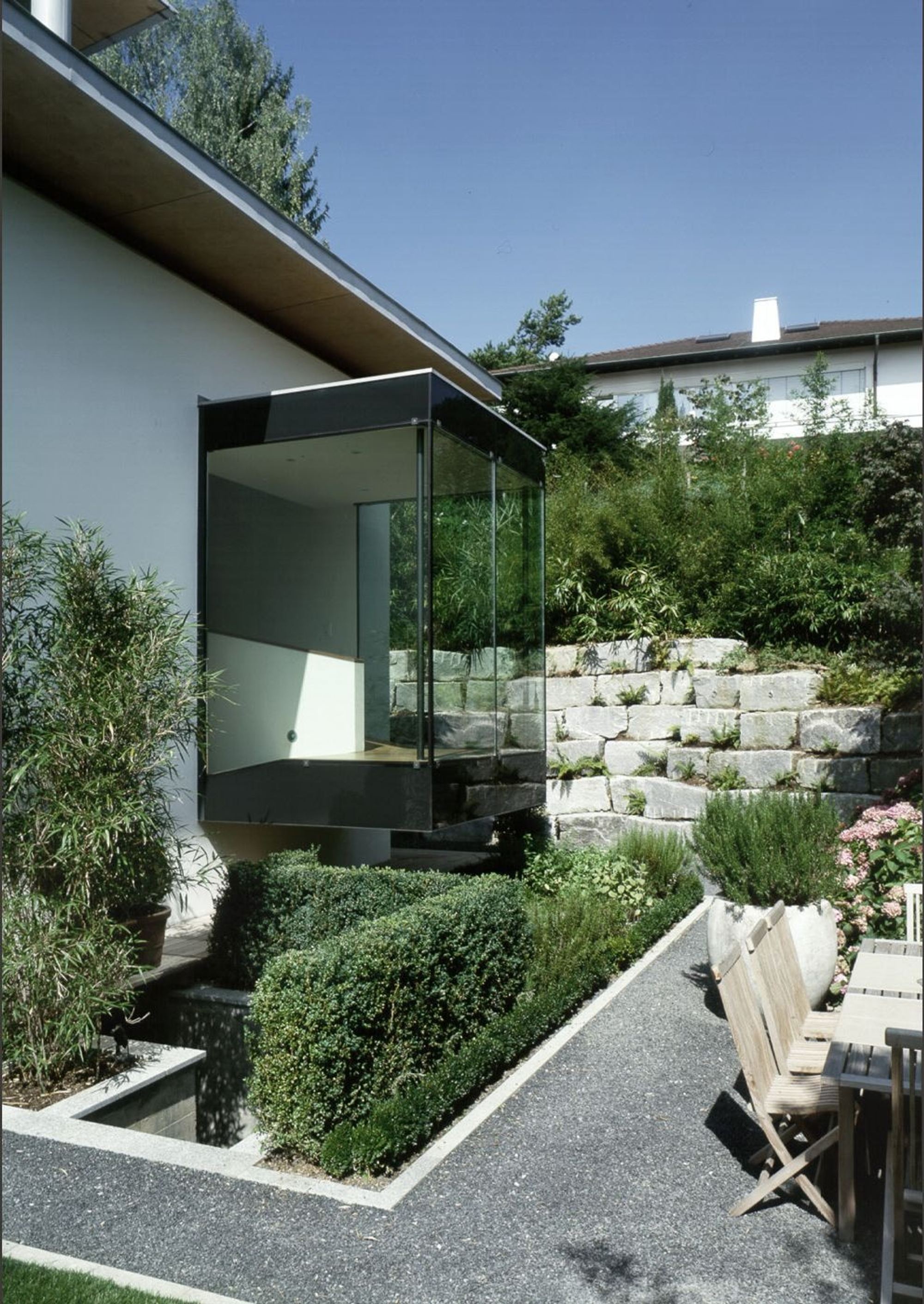 Glass bay window above the garden with stone wall – Single-family house