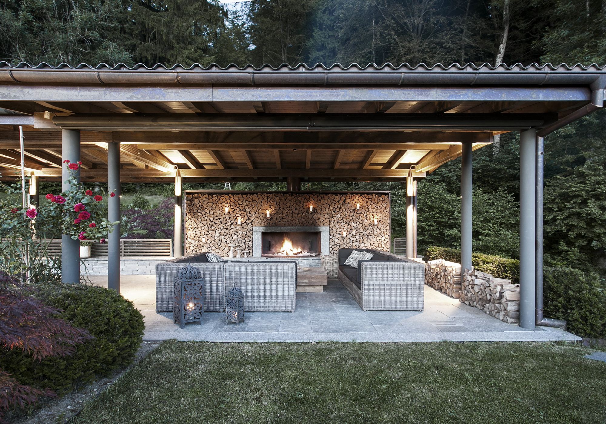 Covered lounge with fireplace and stacked firewood – Interiors and landscape, Stallikon