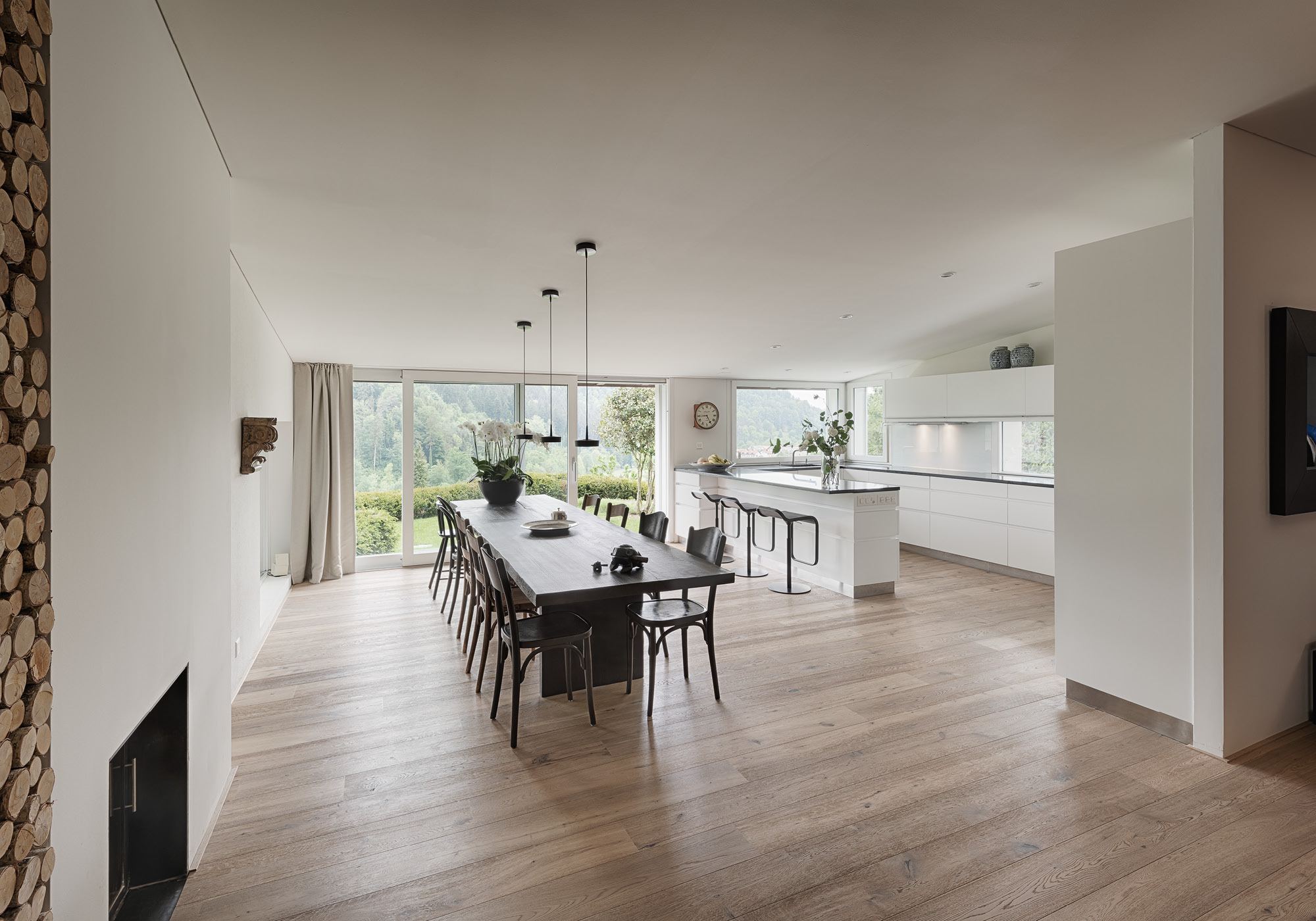 Long dining table with open kitchen behind – Interiors and landscape, Stallikon
