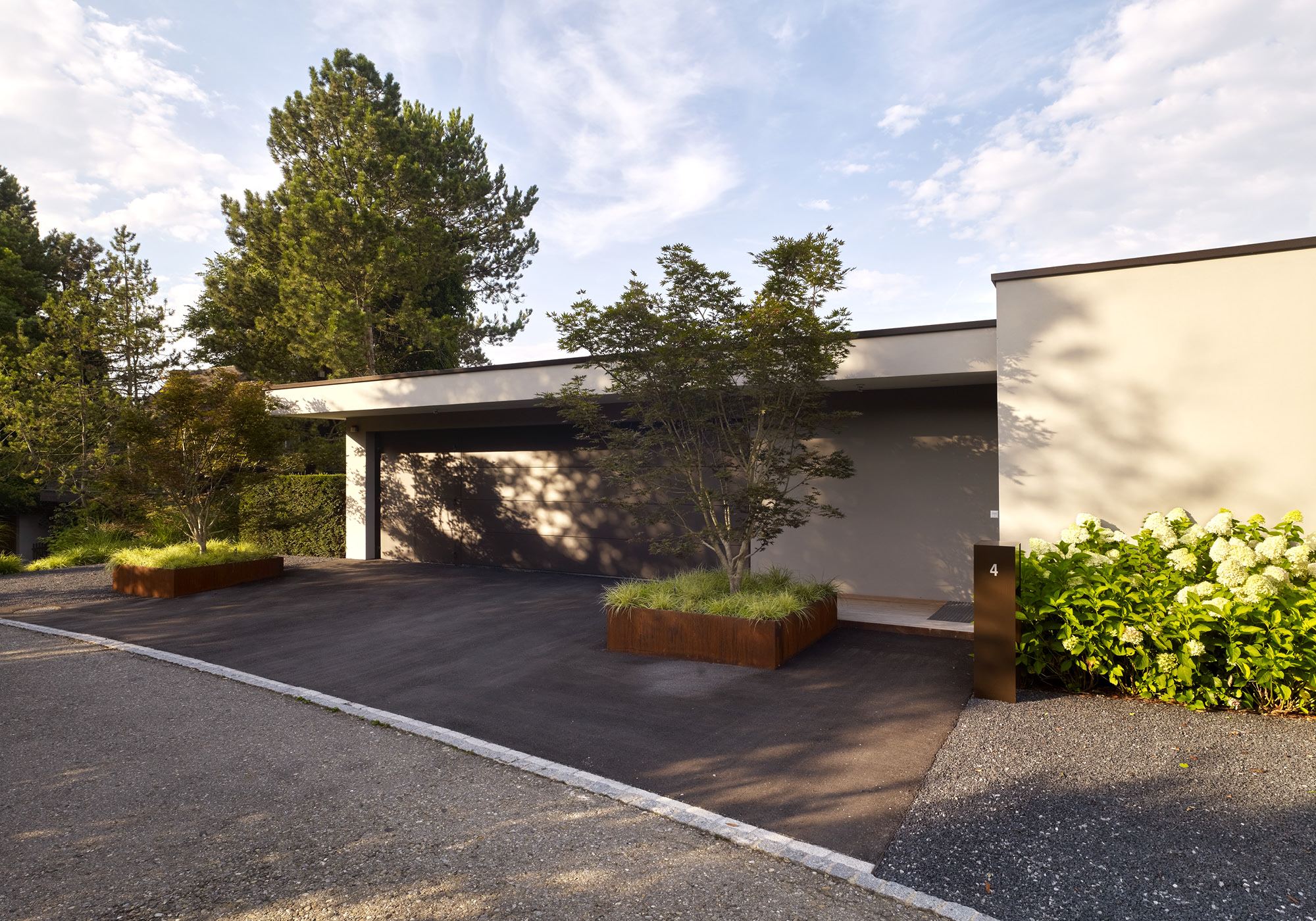 Driveway with pine and weathering steel planters – Single-family house in Oberwil-Lieli