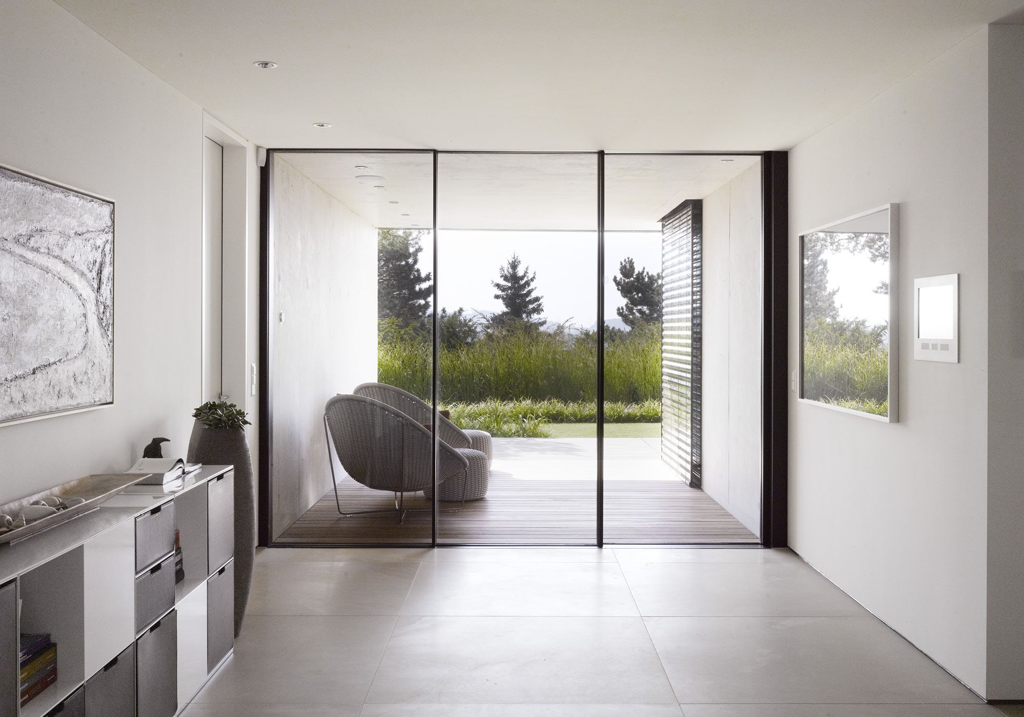 Room with armchair and glass wall to the garden – Single-family house in Uitikon
