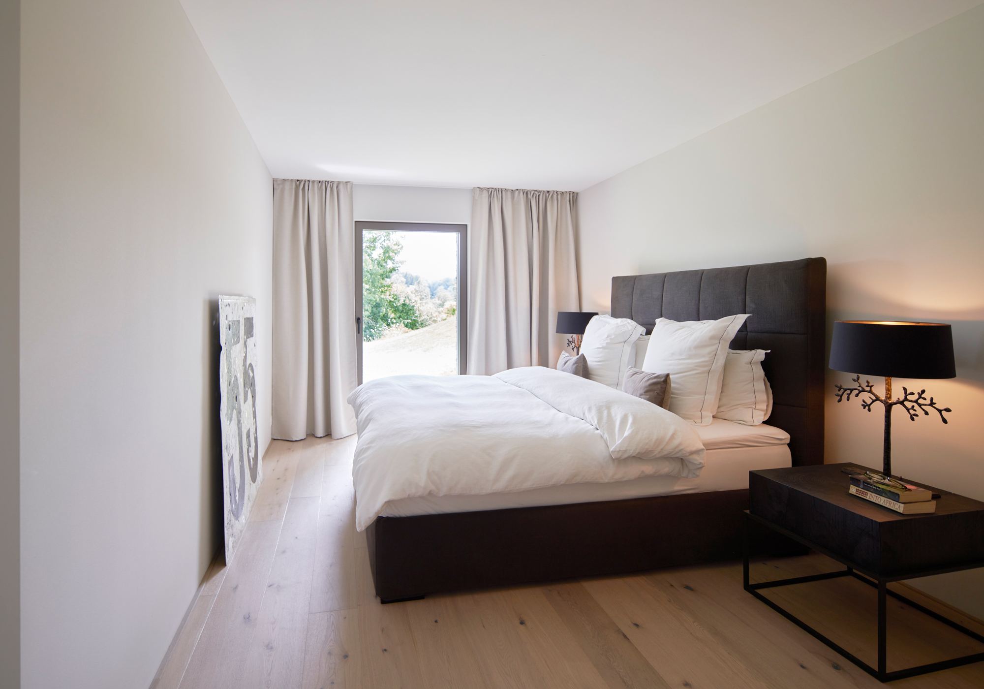 Bedroom with upholstered bed and French window – Interiors and landscape, Wettswil