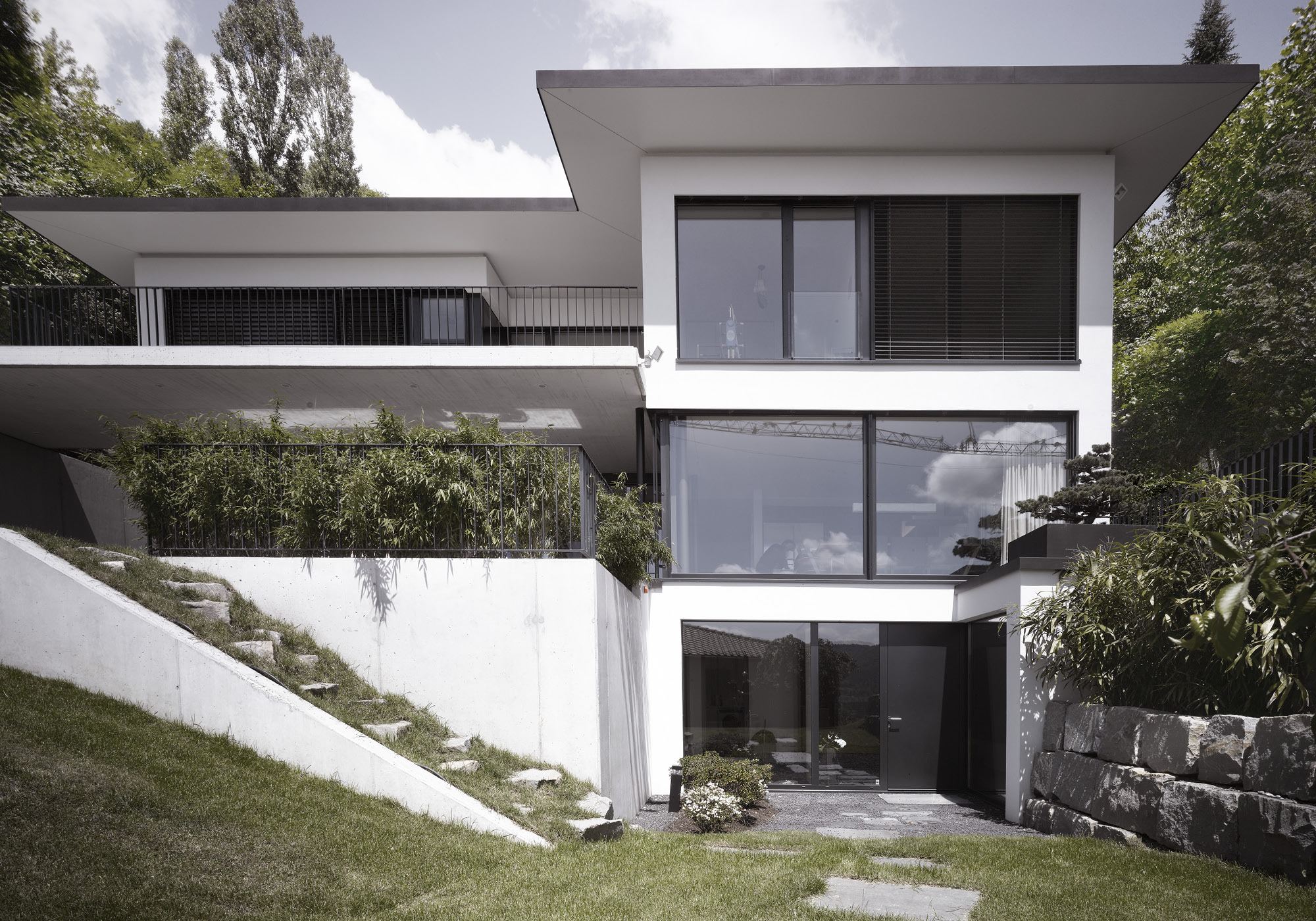White house on the slope with concrete walls – Single-family house in Wettingen