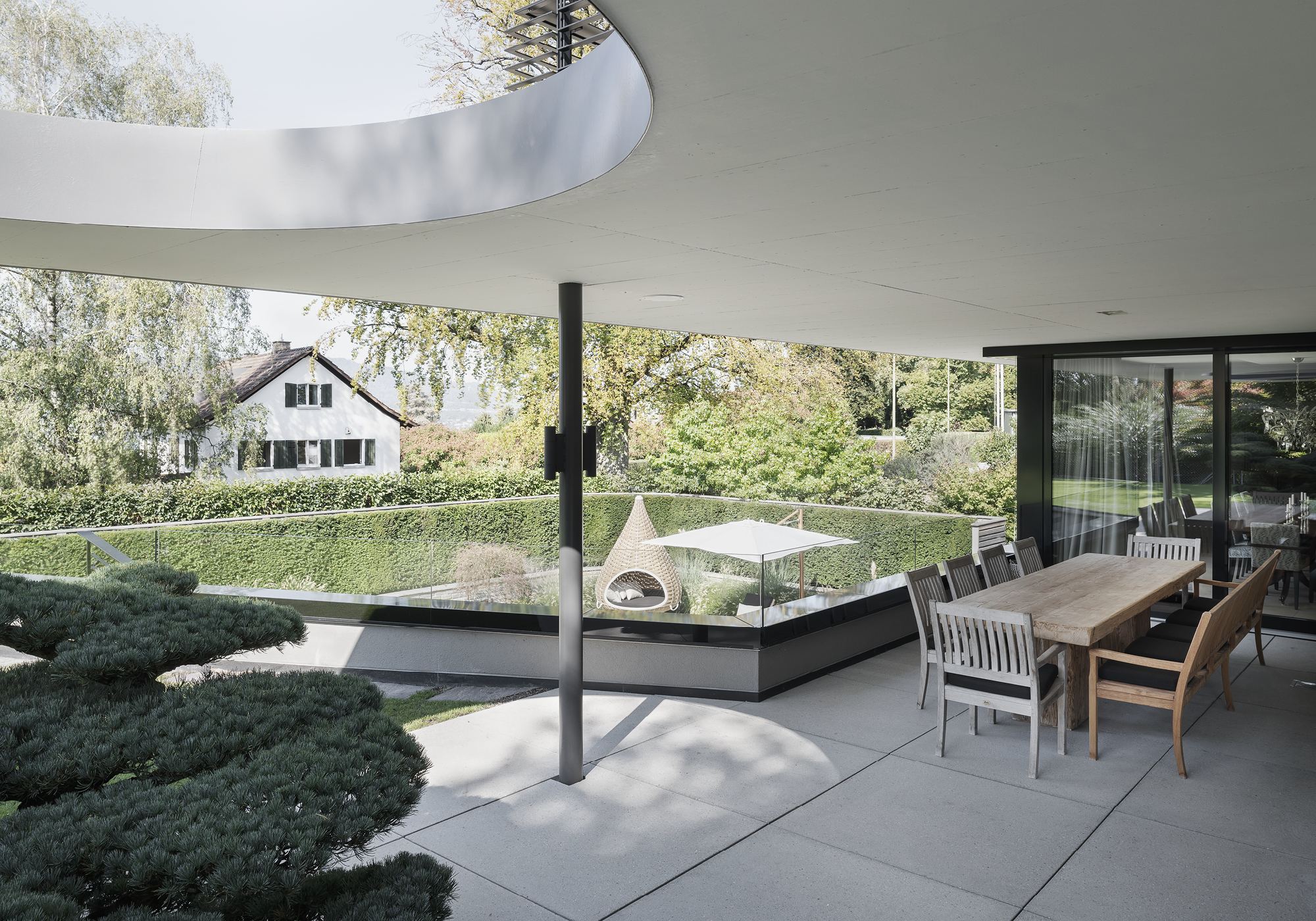 Dining table under the curved canopy – Single-family house in Küsnacht