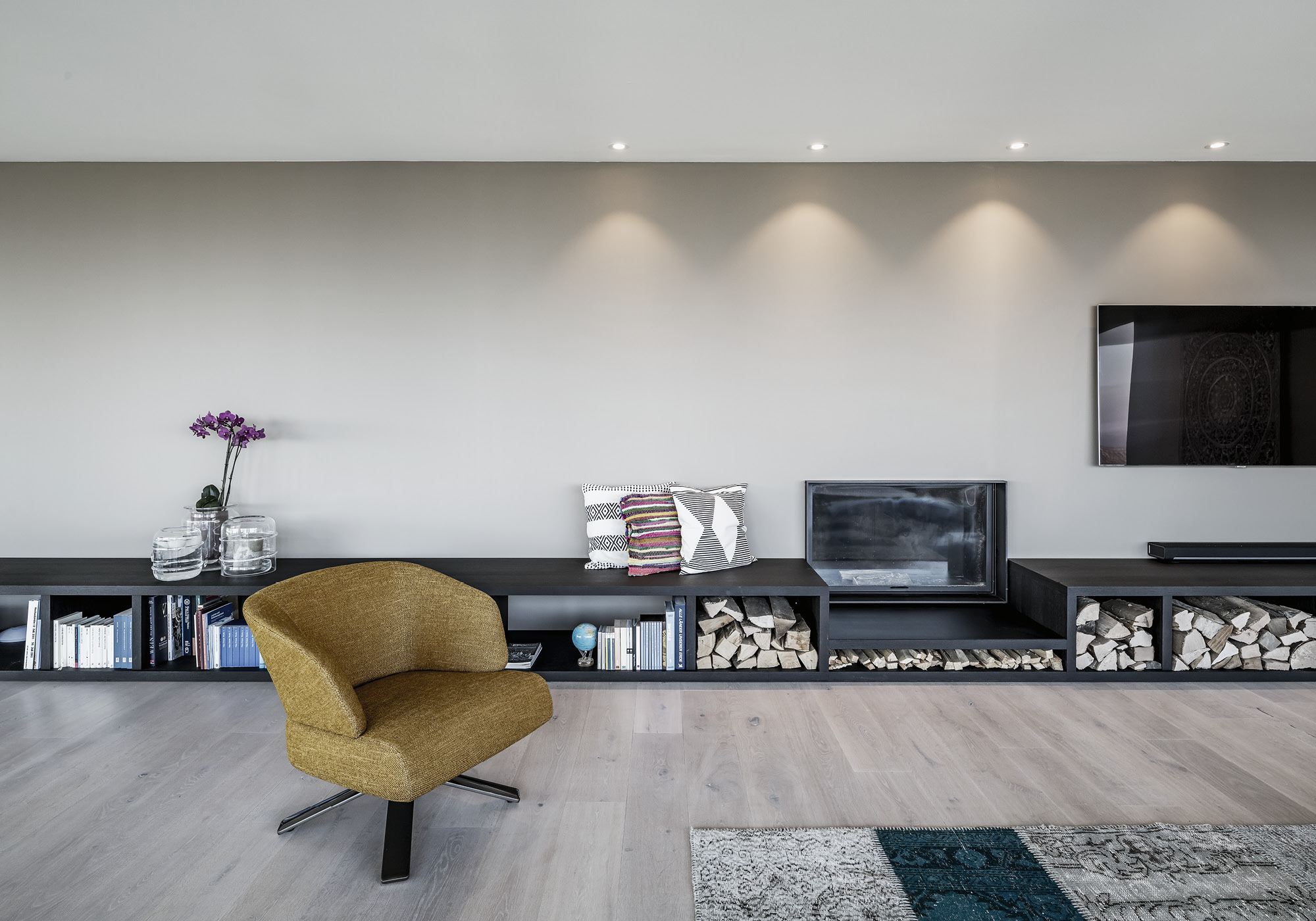 Lowboard with firewood compartments and yellow armchair – Interiors and landscape, Kilchberg