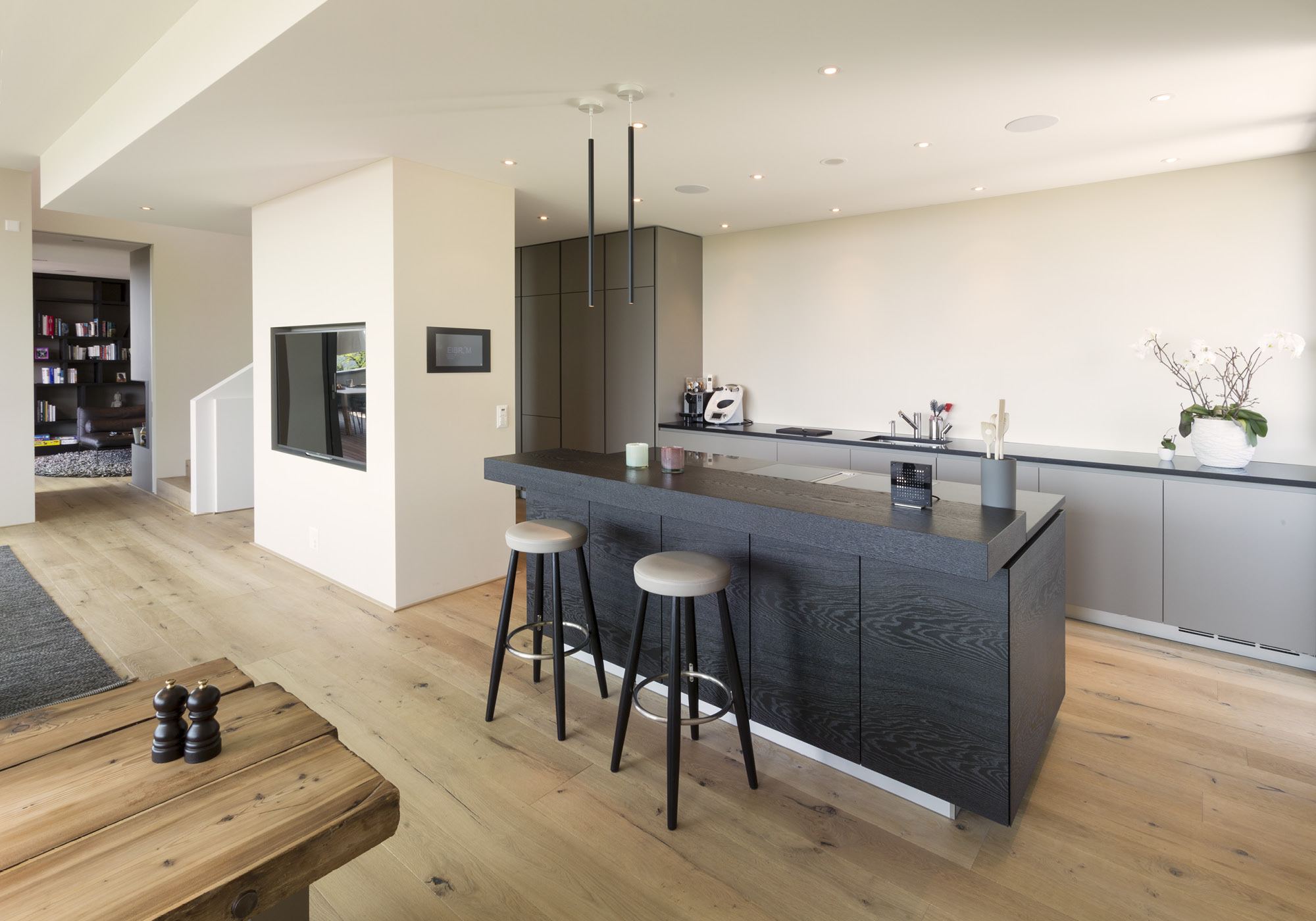 Kitchen area with island and timber bench – Single-family house in Uitikon