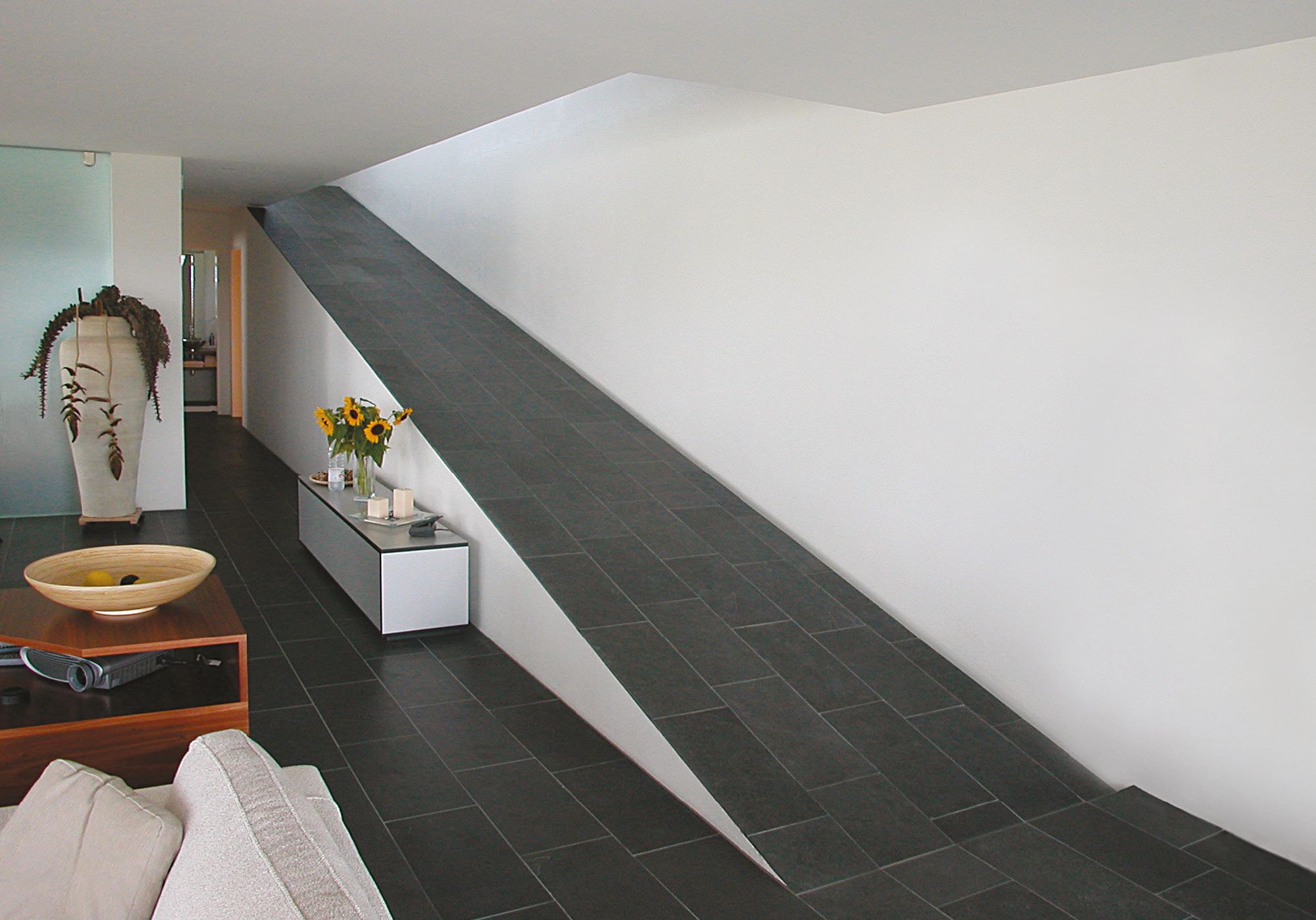 Living space with slate floor and sloping wall – Single-family house in Uitikon