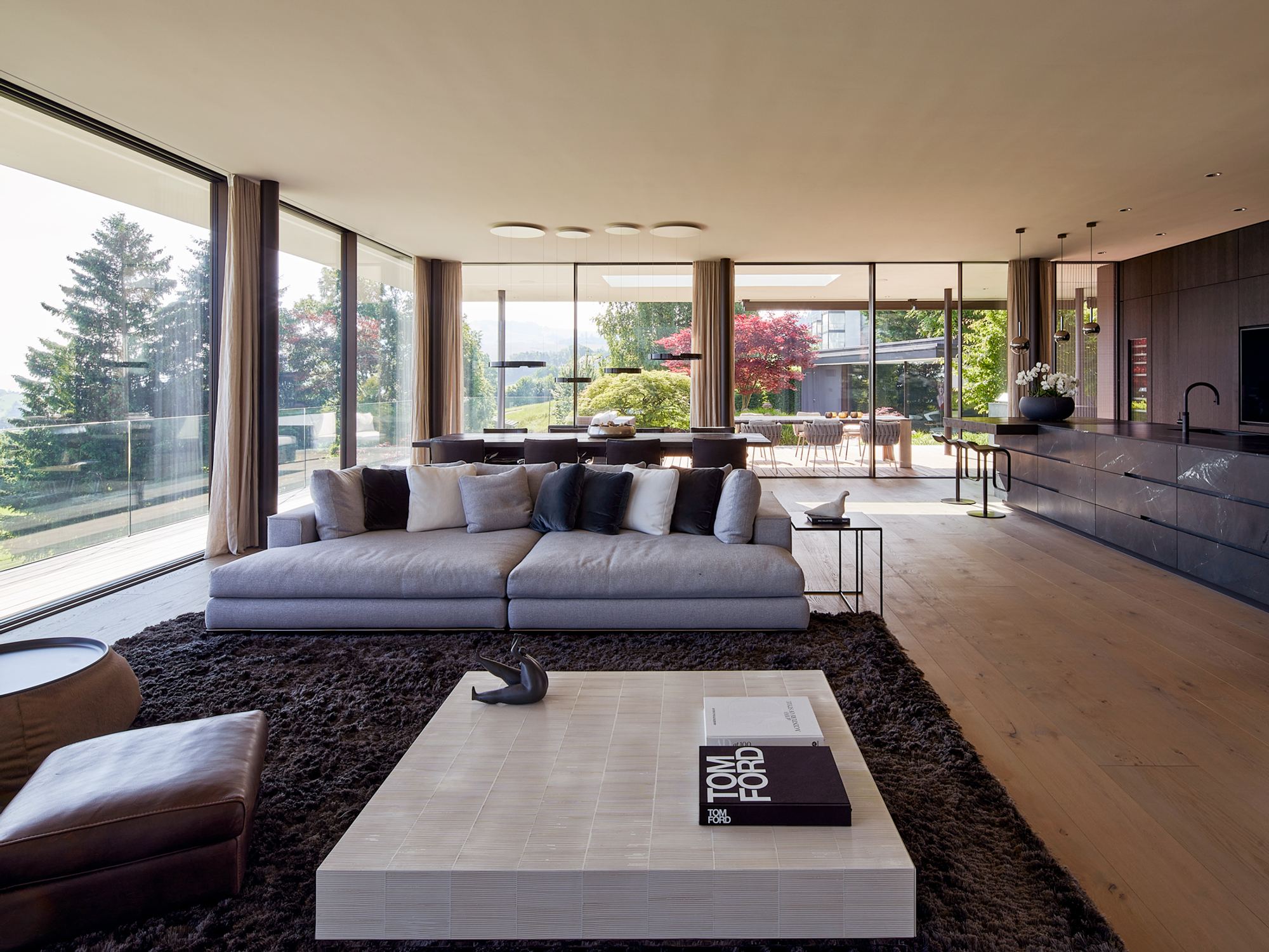 Living room with large sofa and floor-to-ceiling windows to the garden – Single-family house in Schindellegi