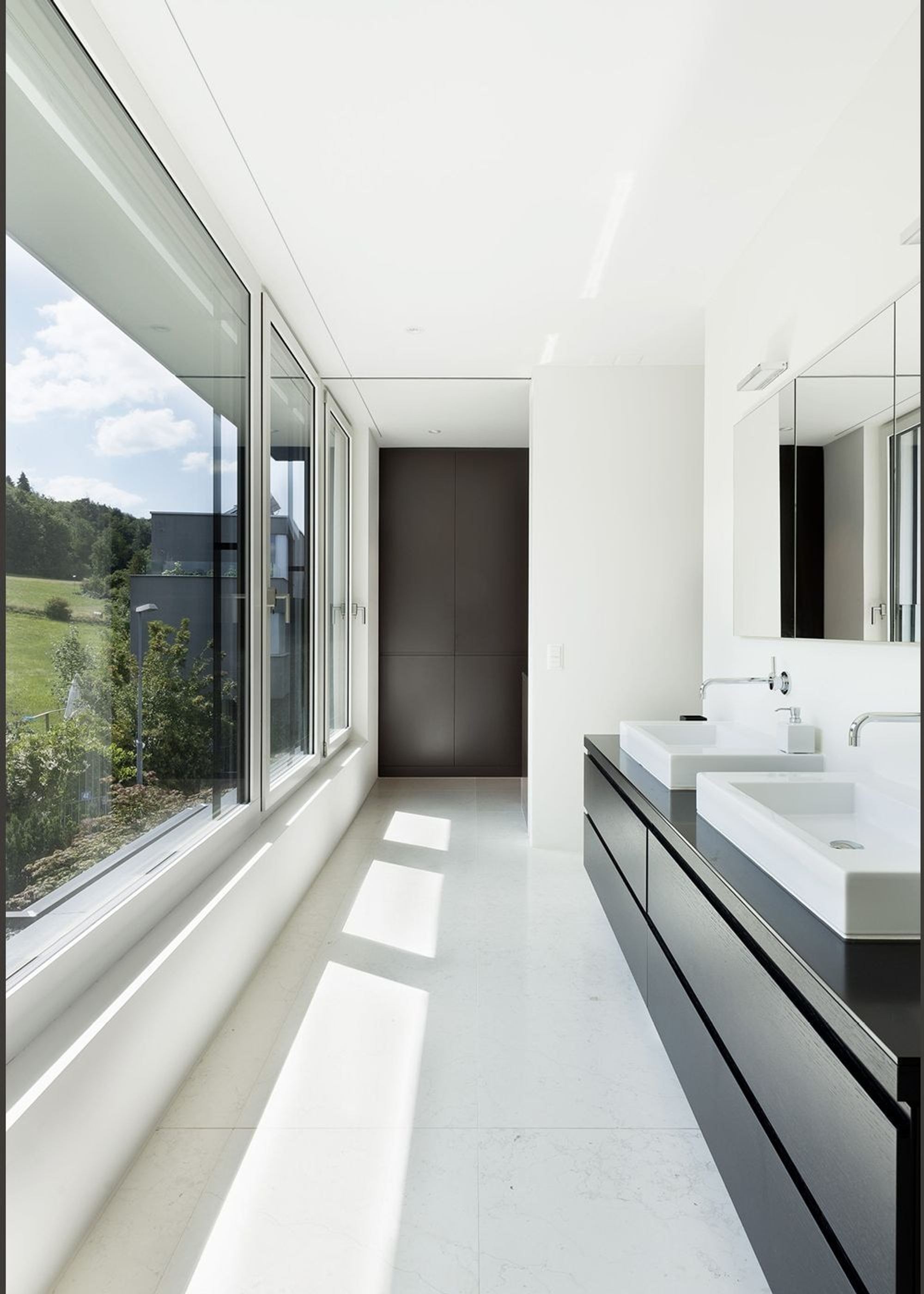 Bathroom with double vanity and long window – Single-family house in Zürich