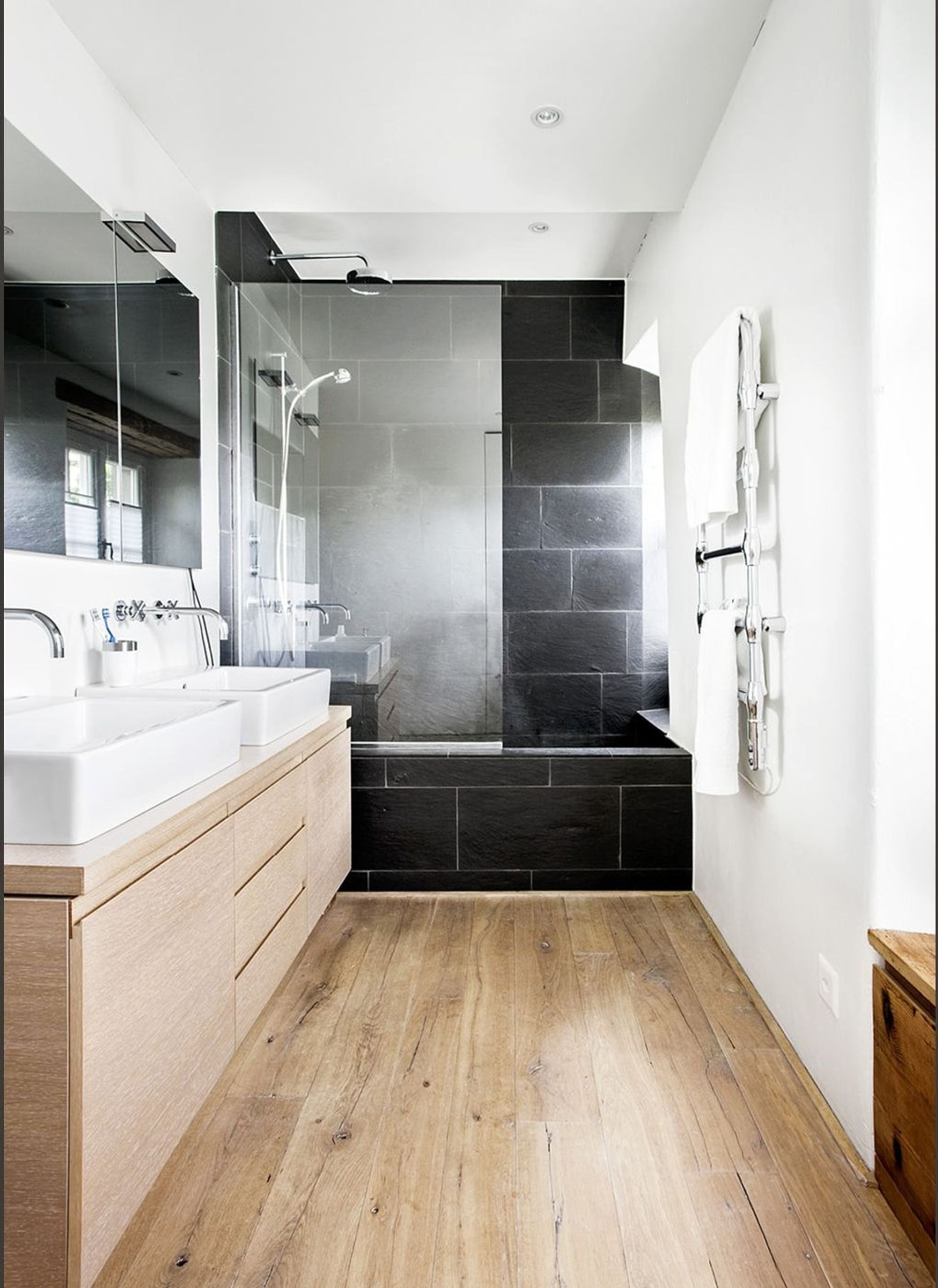 Bathroom with timber vanity and dark bath – Historic conversion in Uerikon
