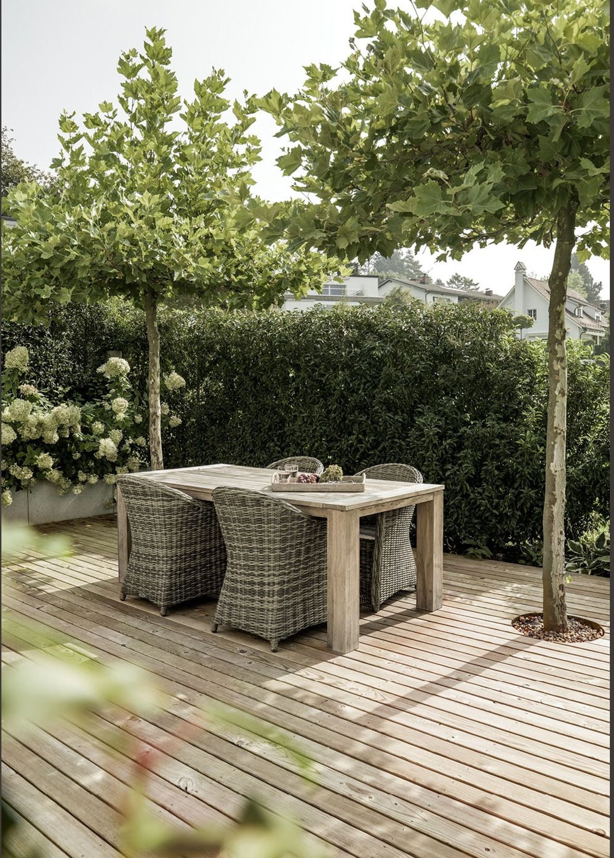 Timber deck with dining table under trees – Single-family house in Uitikon