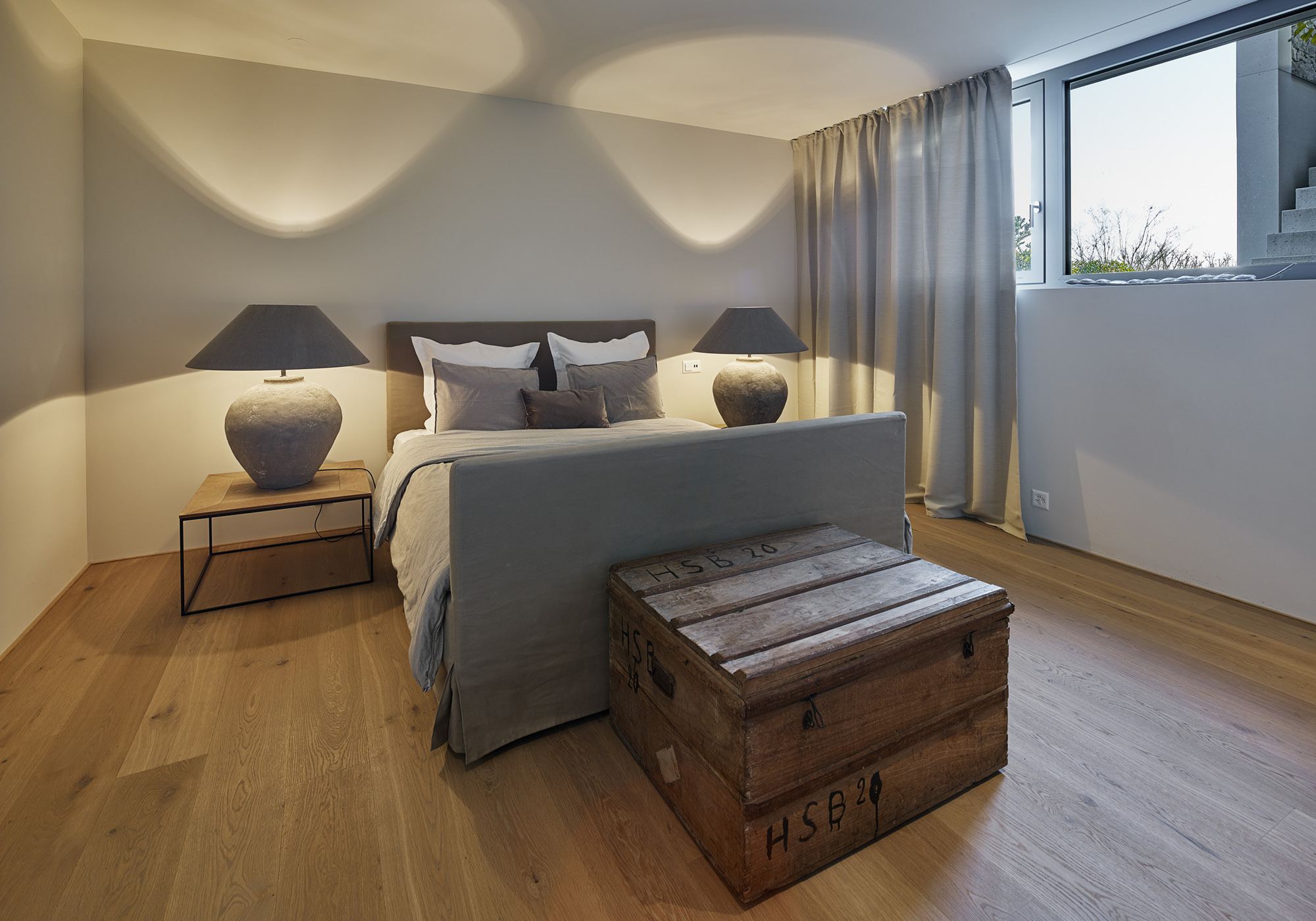 Bedroom with table lamps and timber chest – Single-family house in Uitikon