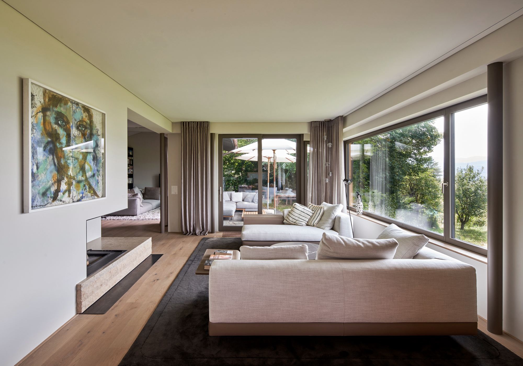Living room with large sofa and window front to the garden – Interiors and landscape, Meilen