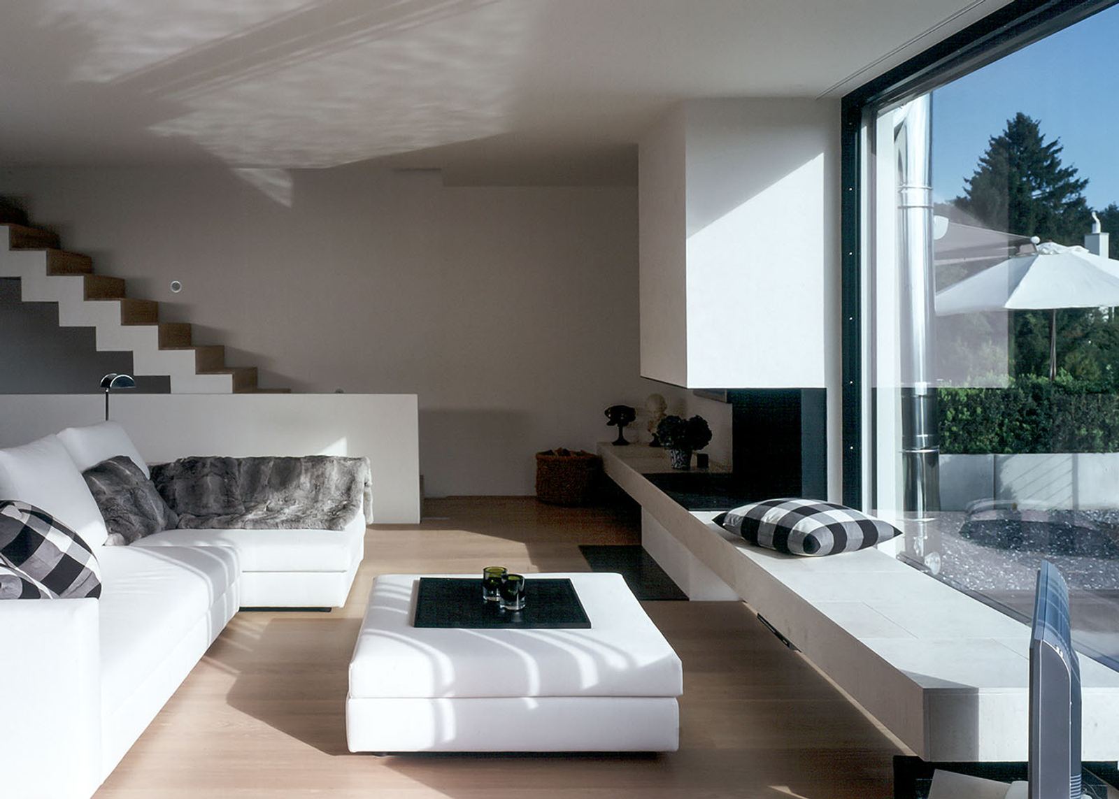 Living space with white corner sofa and staircase