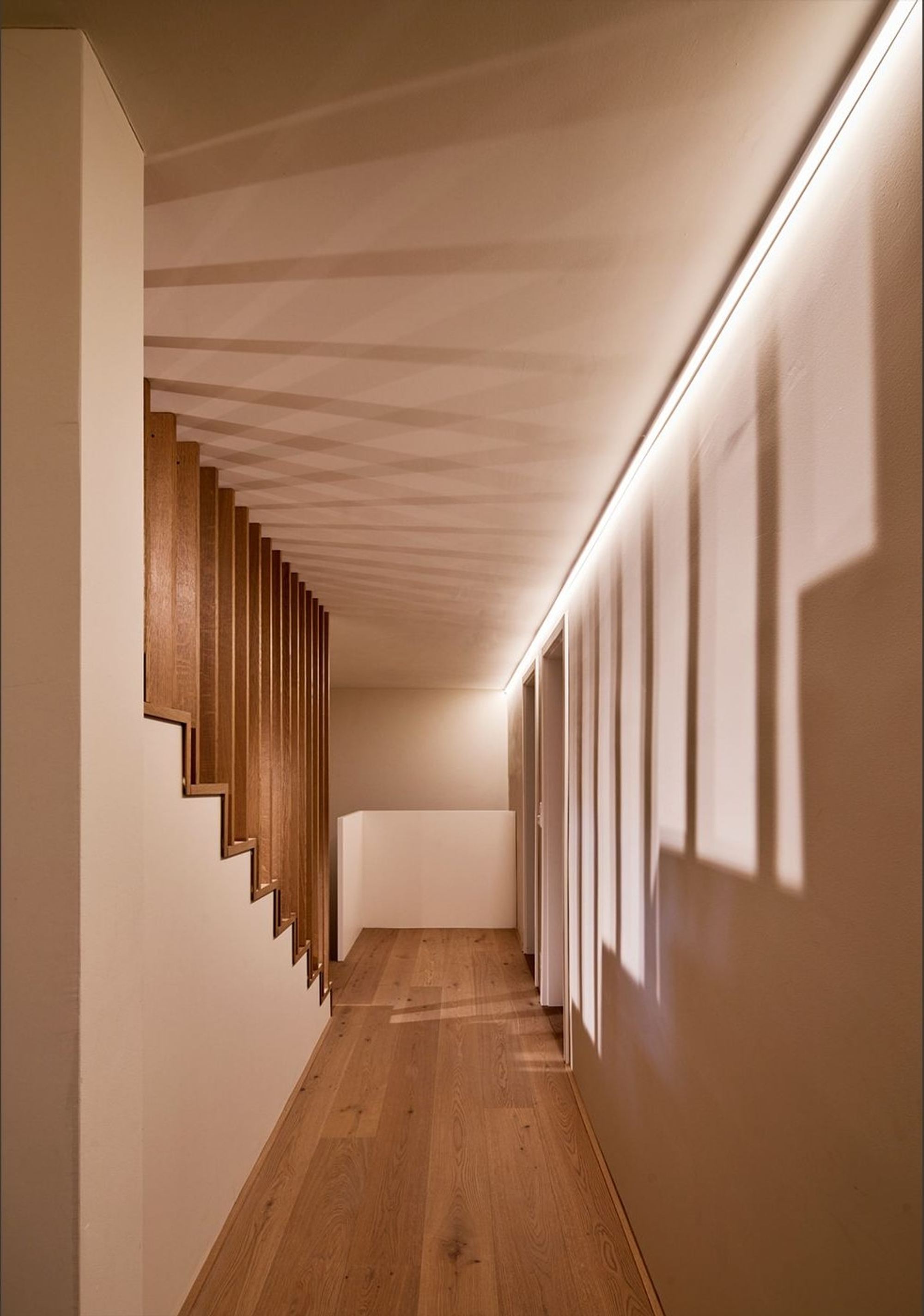 Hallway with timber slats and indirect lighting – Interiors and landscape, Meilen