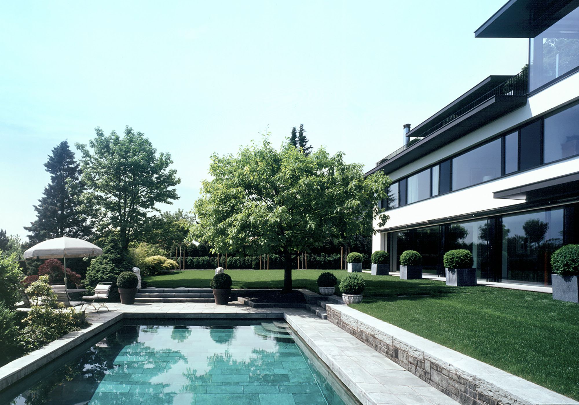 Pool with natural stone edge in front of the house – Single-family house in Uitikon