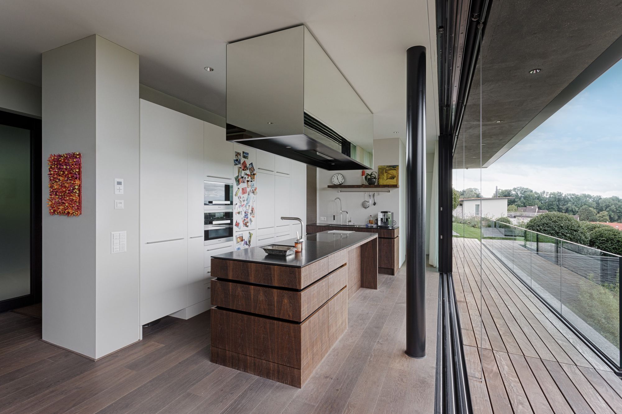 Kitchen with timber island and view of the terrace – Single-family house in Uitikon