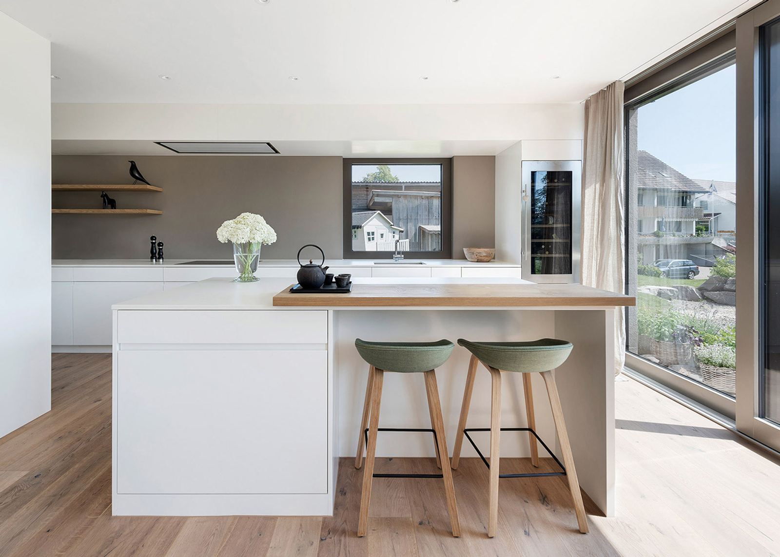 White kitchen with timber counter and bar stools