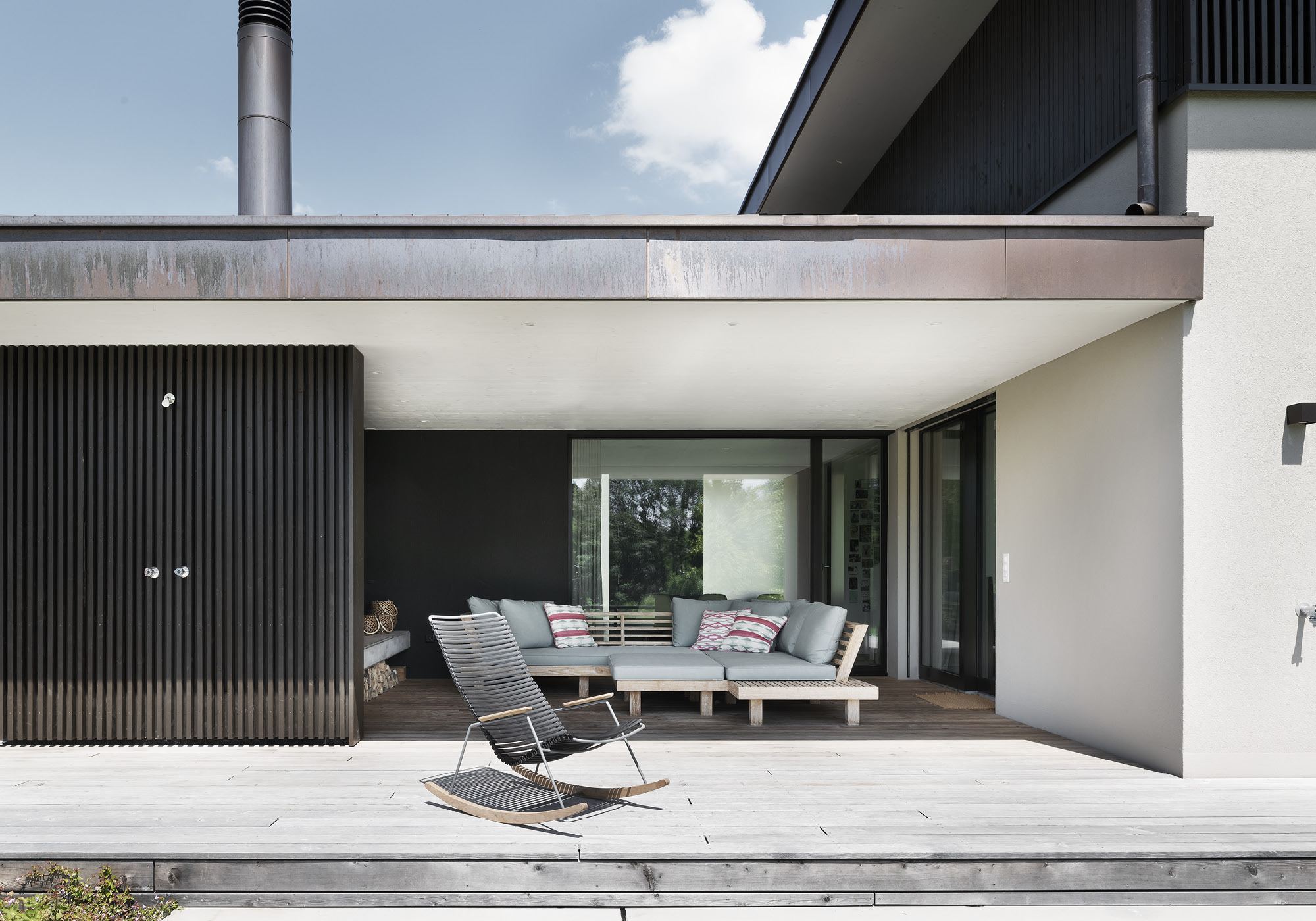 Covered seating area with lounge furniture and timber deck – Single-family house in Grüningen