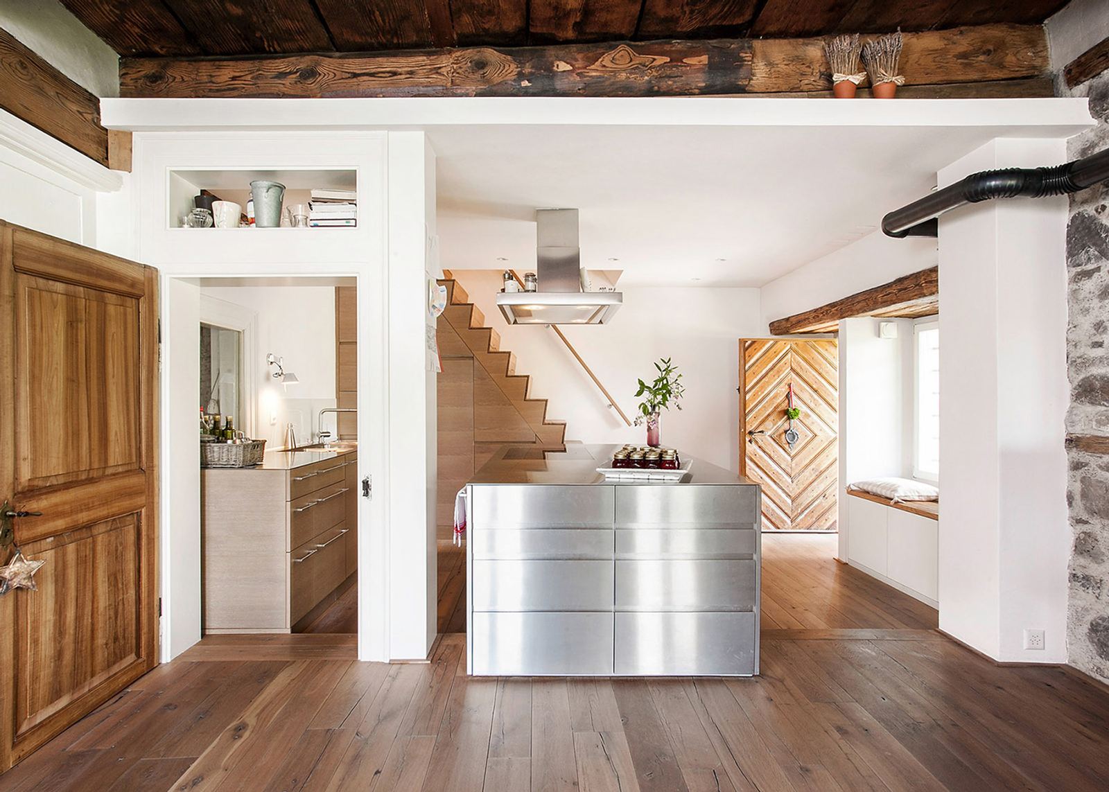 Stainless steel kitchen beneath old ceiling beams