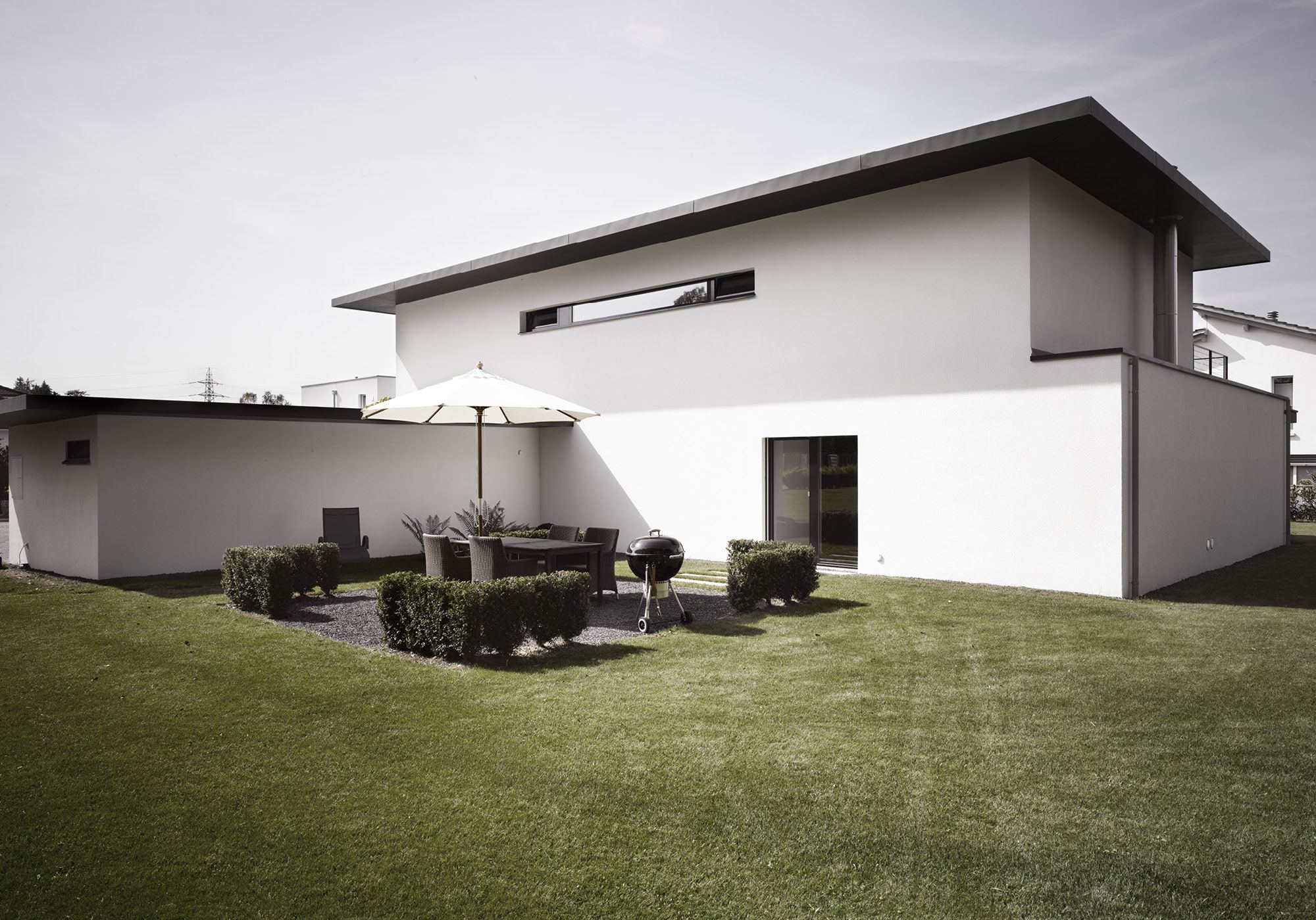 Garden side with seating area and parasol – Single-family house in Möriken