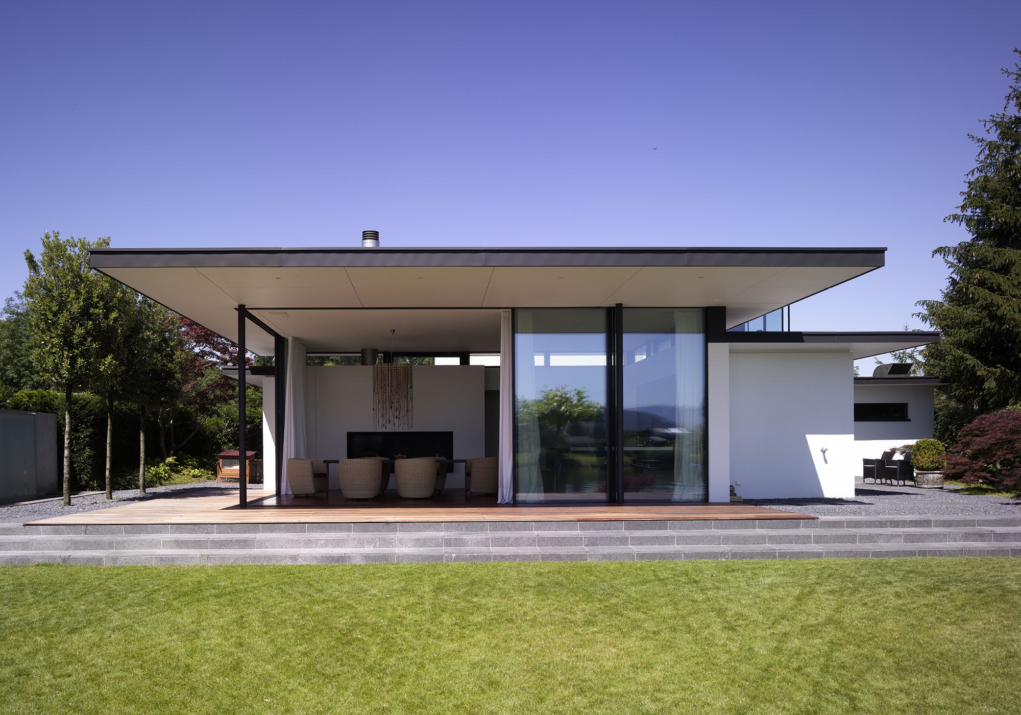 Flat-roofed house with timber deck and lawn – Single-family house in Lachen