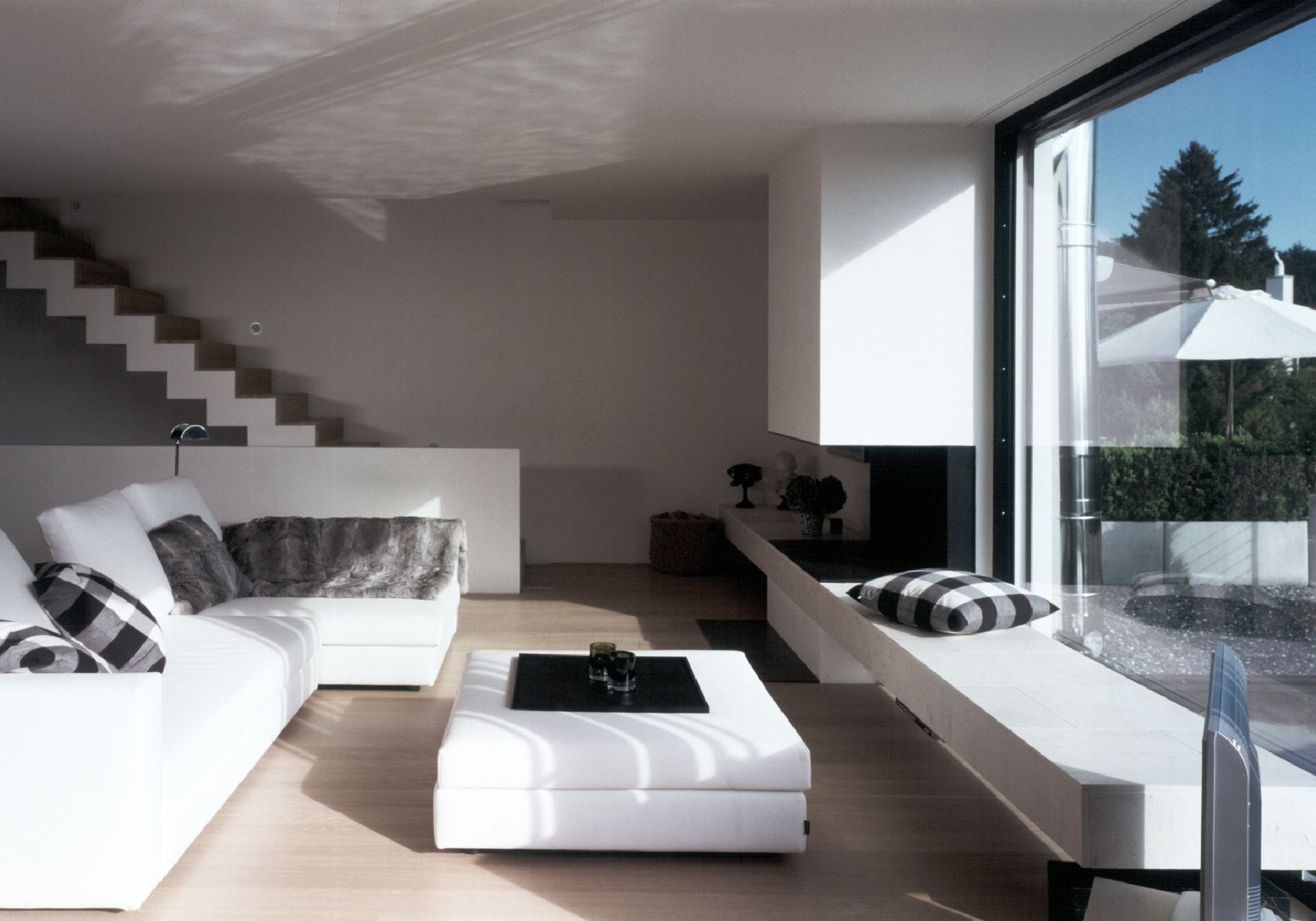 Living space with white corner sofa and staircase – Single-family house in Davos Platz