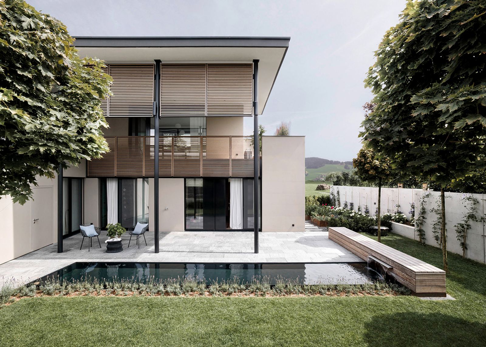 House with timber balcony behind the pool