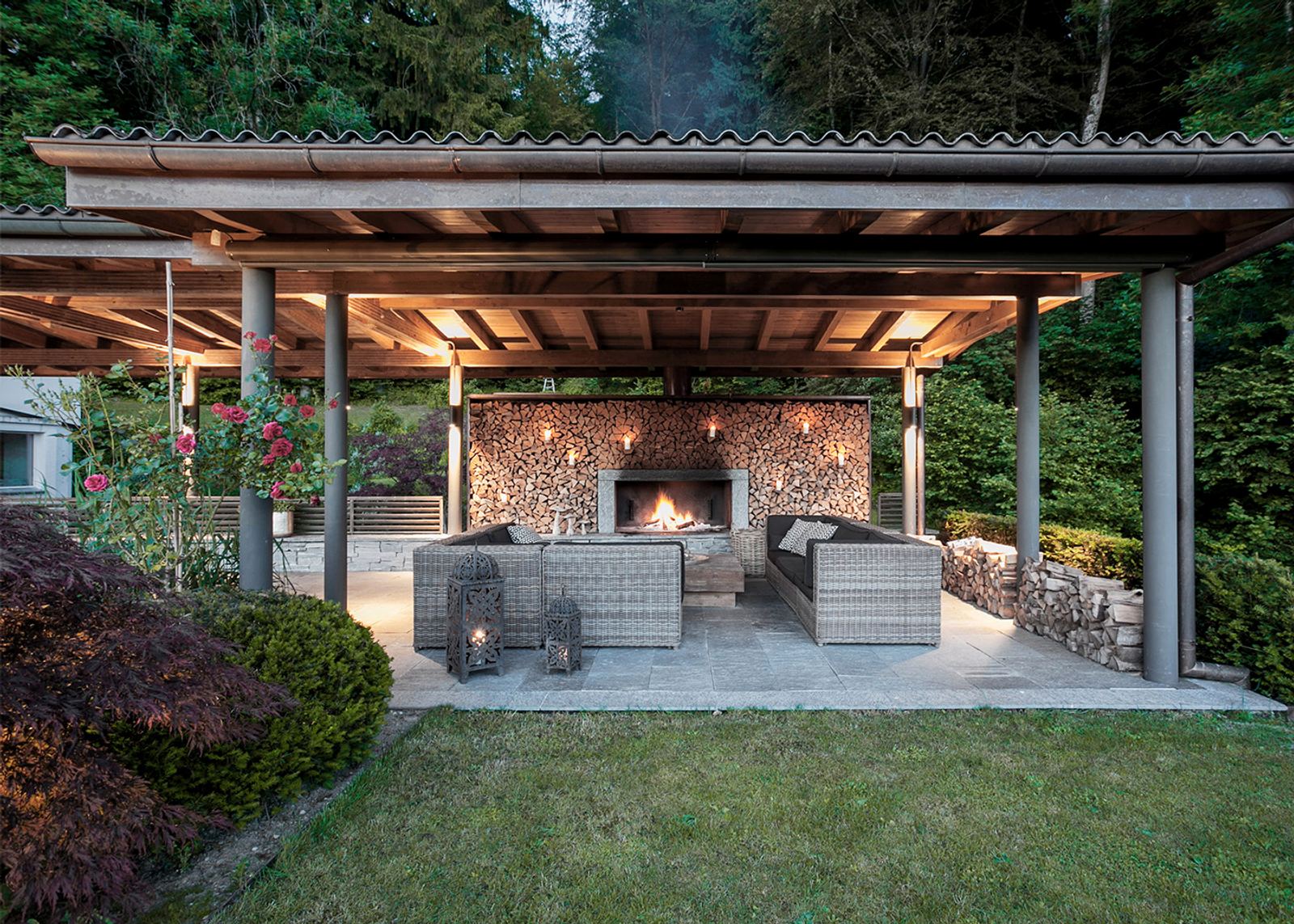 Covered lounge with fireplace and stacked firewood
