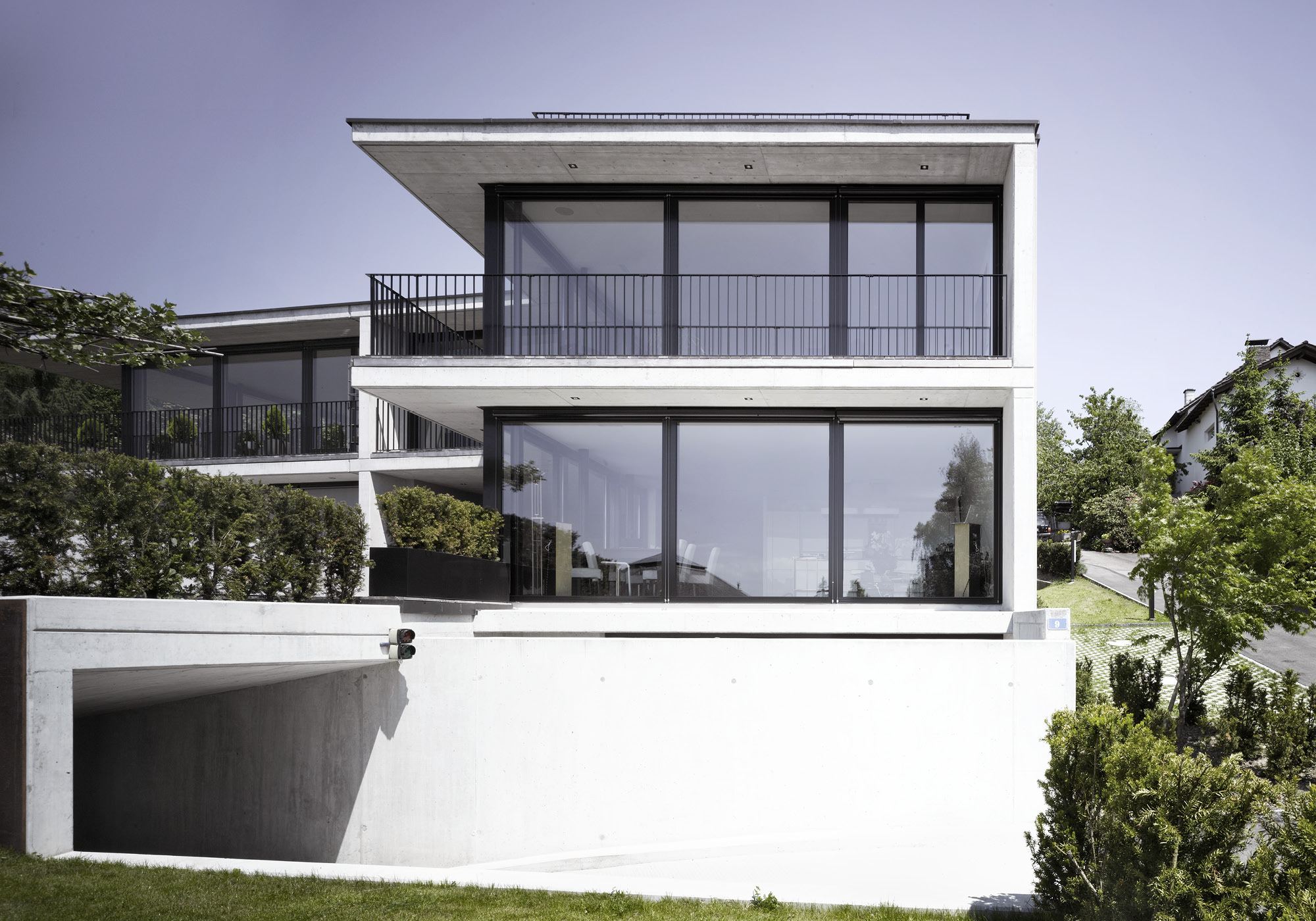 White facade above the underground car park entrance – Apartment building in Uitikon