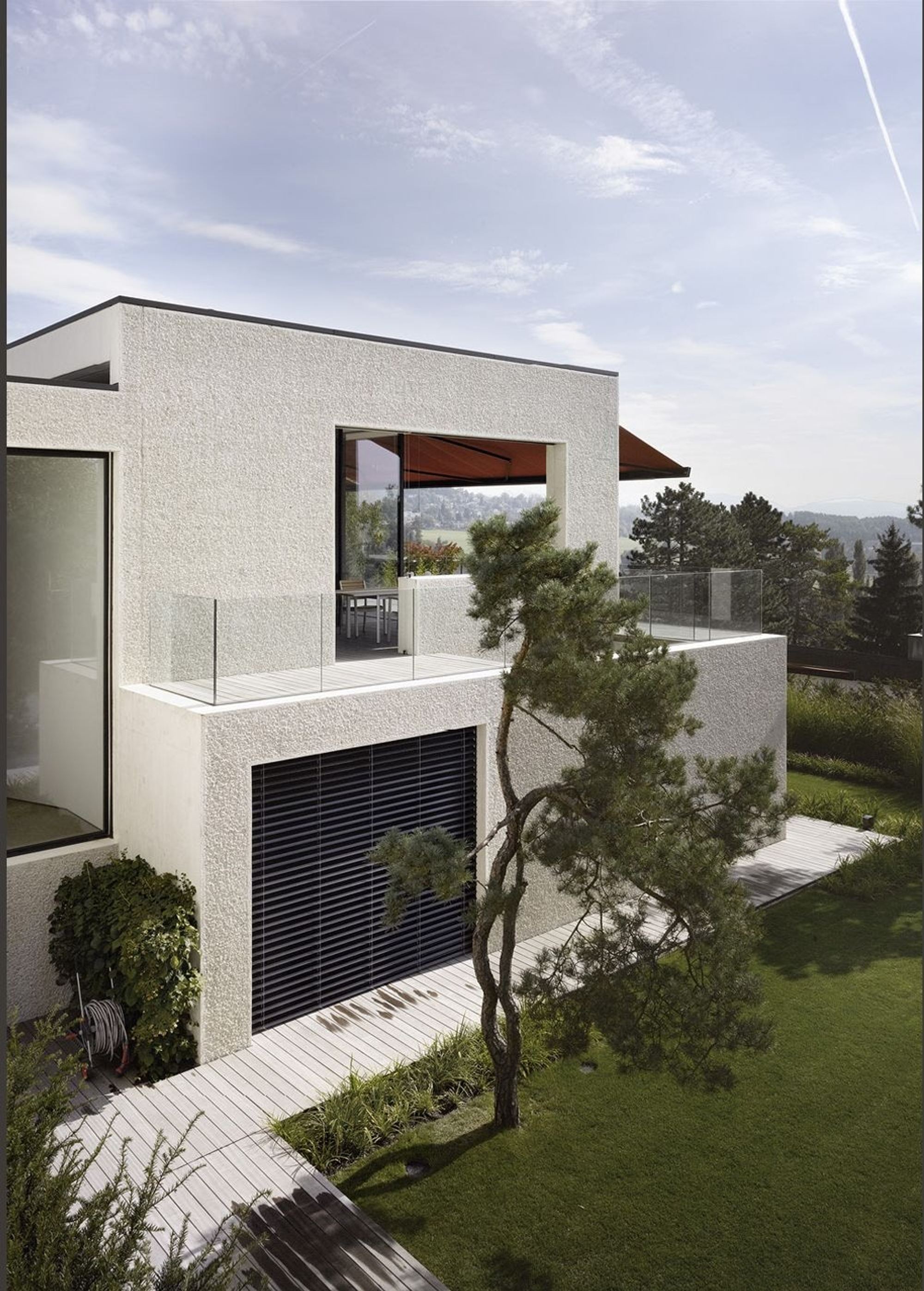 Corner of the house with pine and garage door – Single-family house in Uitikon