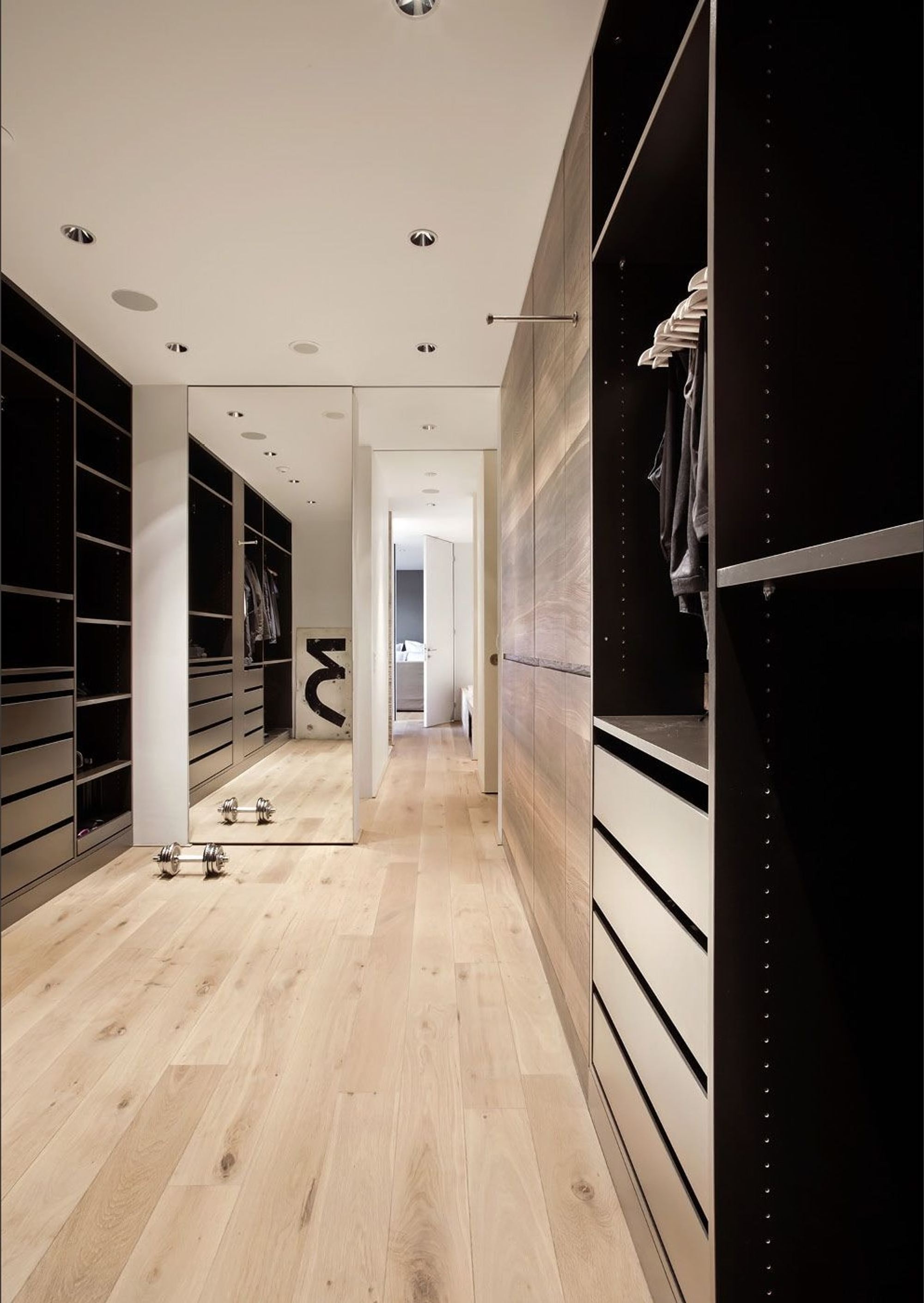 Walk-in wardrobe with dark built-in units – Apartment building in Uitikon