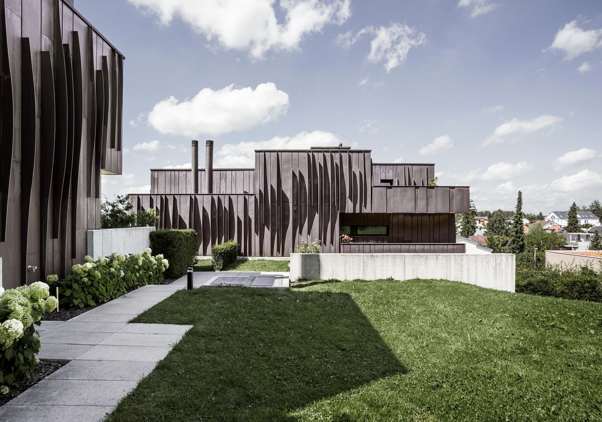 Apartment building with dark metal facade and lawn – Apartment building in Uitikon