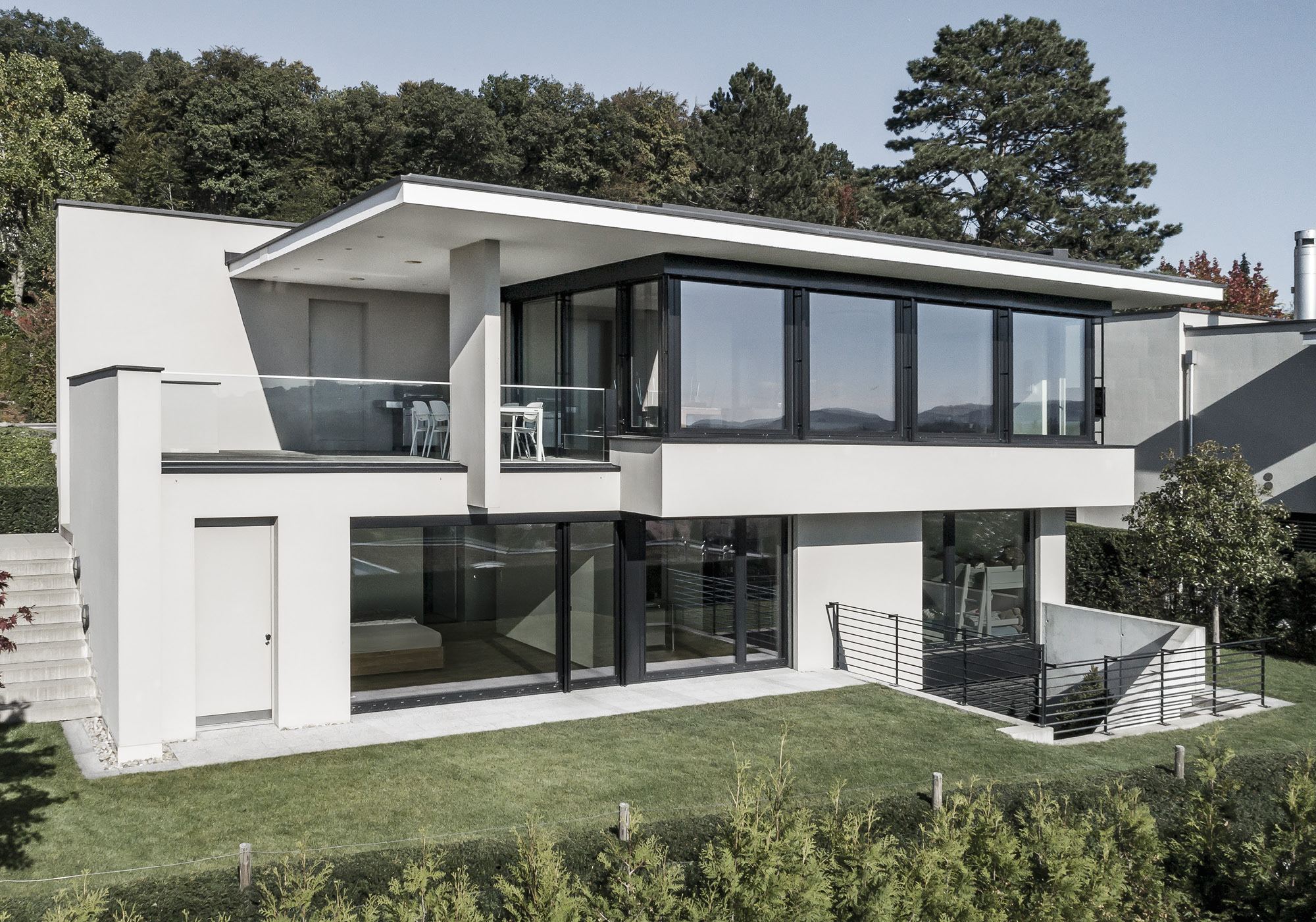 Facade with terrace and lawn on the slope – Single-family house in Uitikon