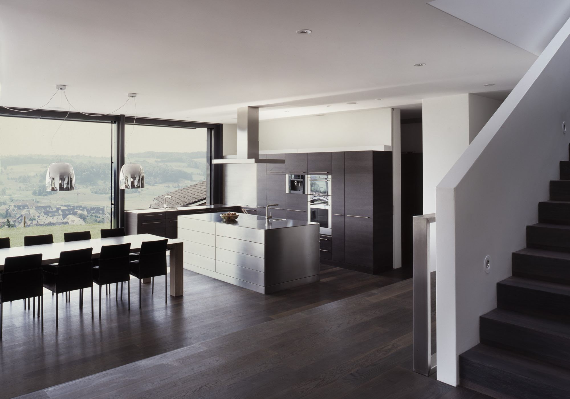 Open kitchen with dining table and staircase – Single-family house in Bonstetten