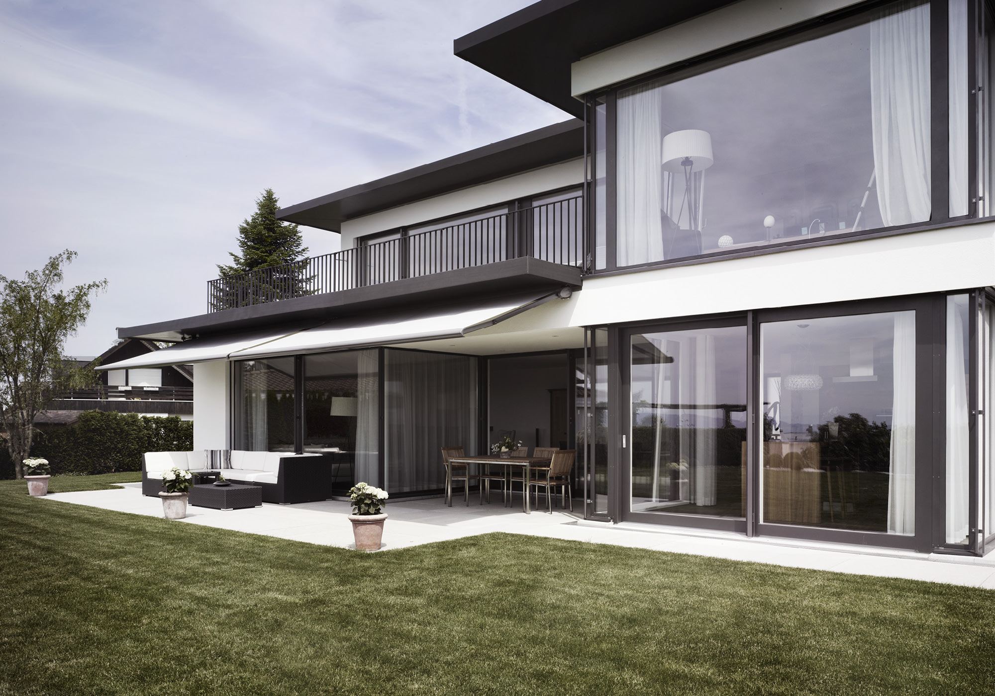Garden side with awning and large windows – Single-family house in Russikon