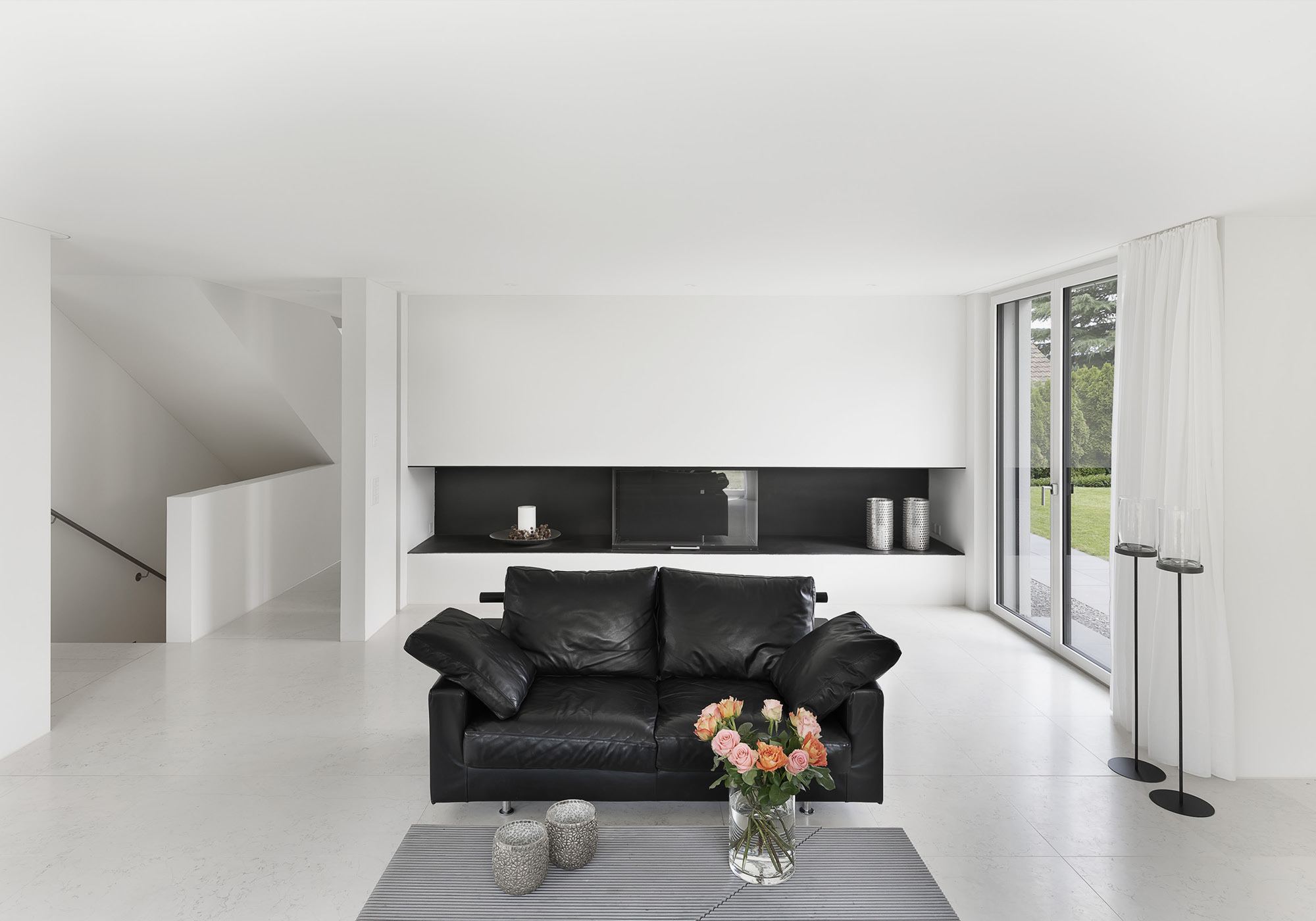 Living area with black leather sofa and light floor – Single-family house in Zürich