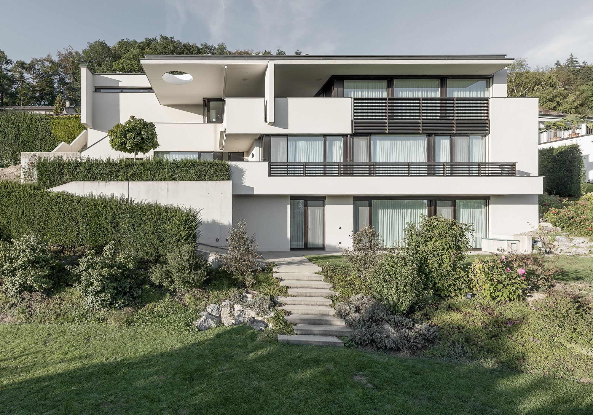Terraced house with white parapets on the slope – Single-family house in Uitikon