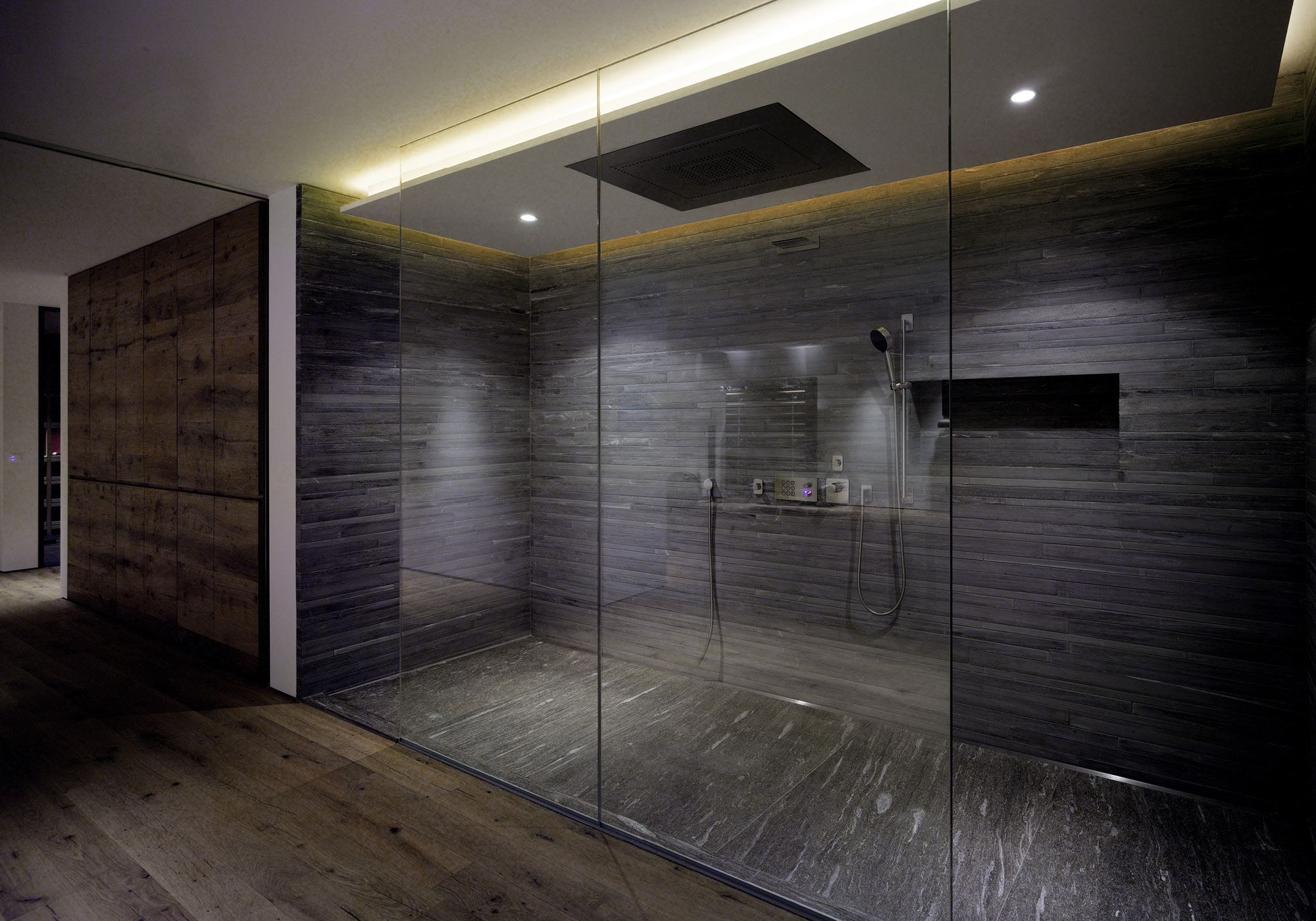 Large shower with glass wall and dark stone – Single-family house in Uitikon