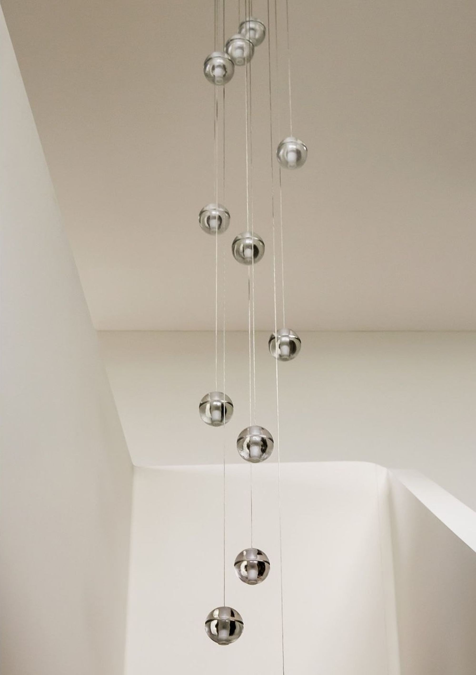 Globe pendants in the tall stairwell – Single-family house in Schindellegi