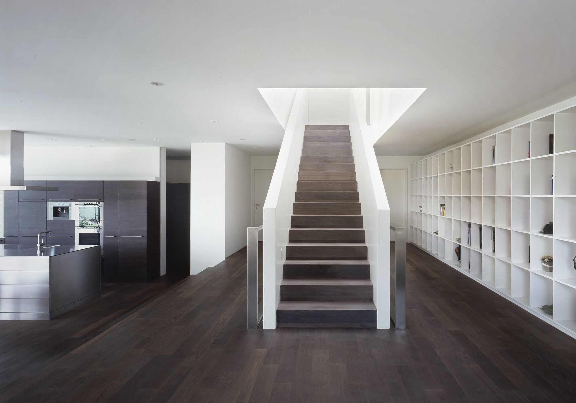 Staircase with white shelving and dark treads – Single-family house in Bonstetten