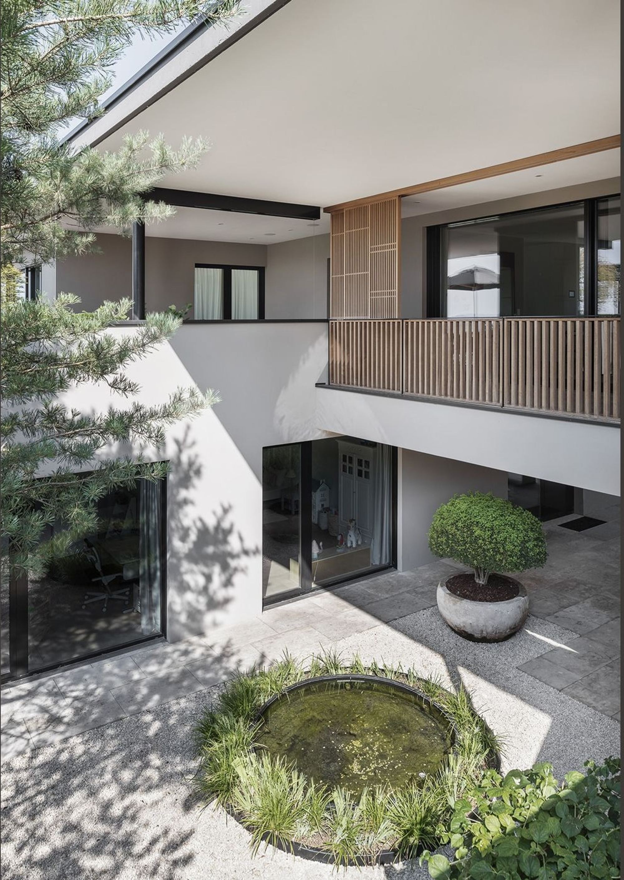 Round water basin below the timber balcony – Single-family house in Schindellegi
