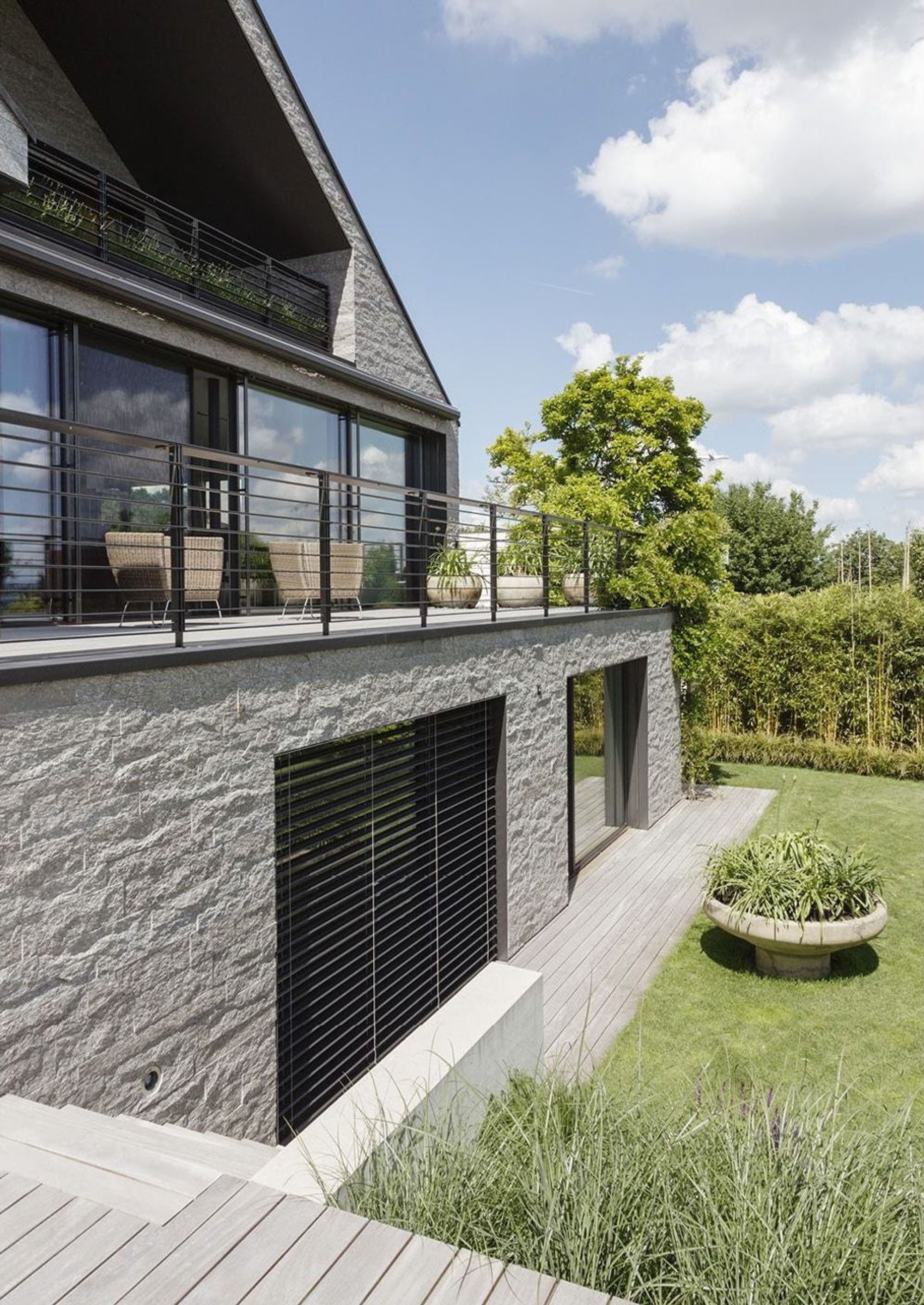 Gartenseite mit Natursteinsockel und Balkon – Einfamilienhaus in Neerach