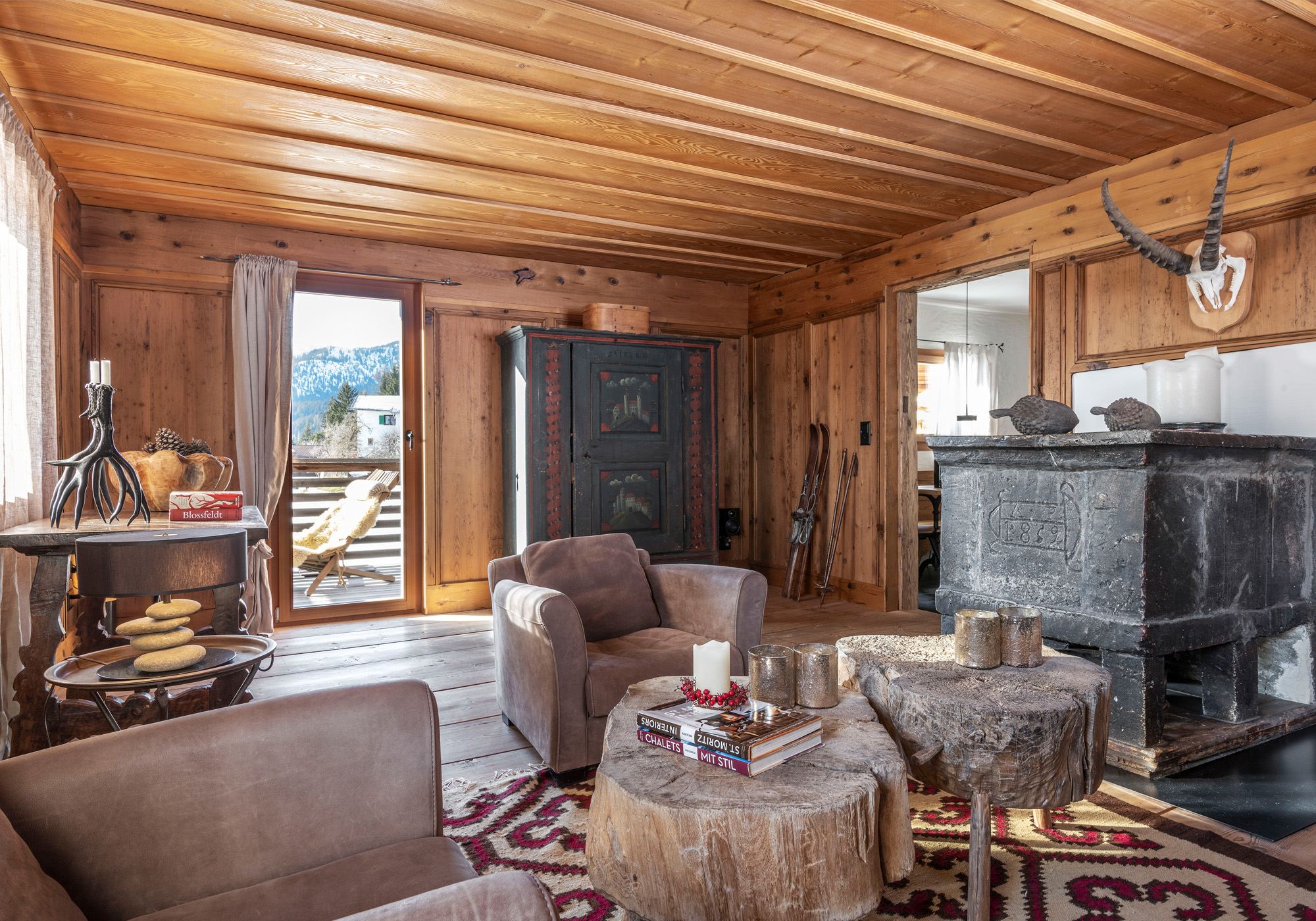 Parlour with timber panelling and large stone stove – Historic conversion in Fidaz