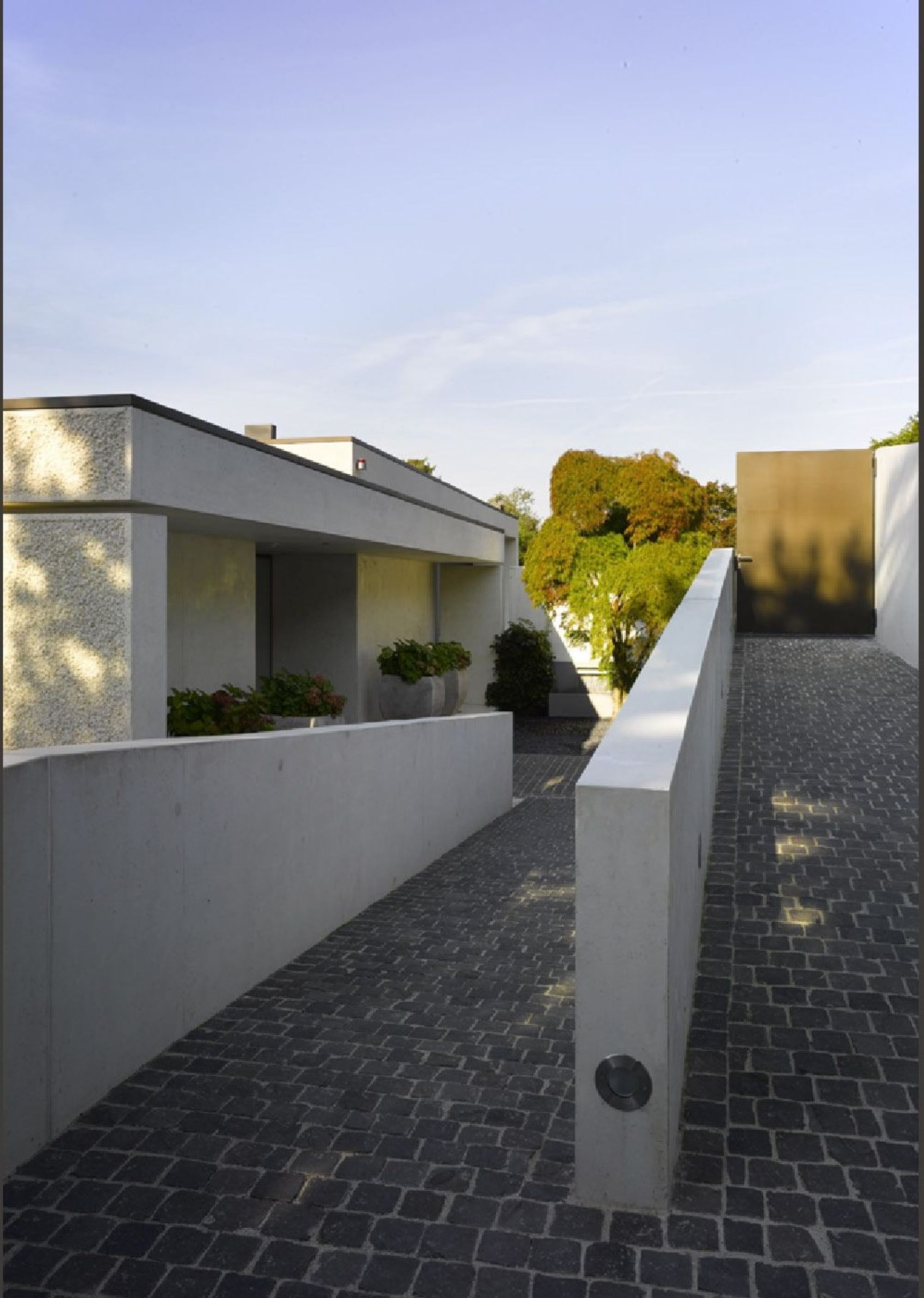 Paved access between walls – Single-family house in Uitikon