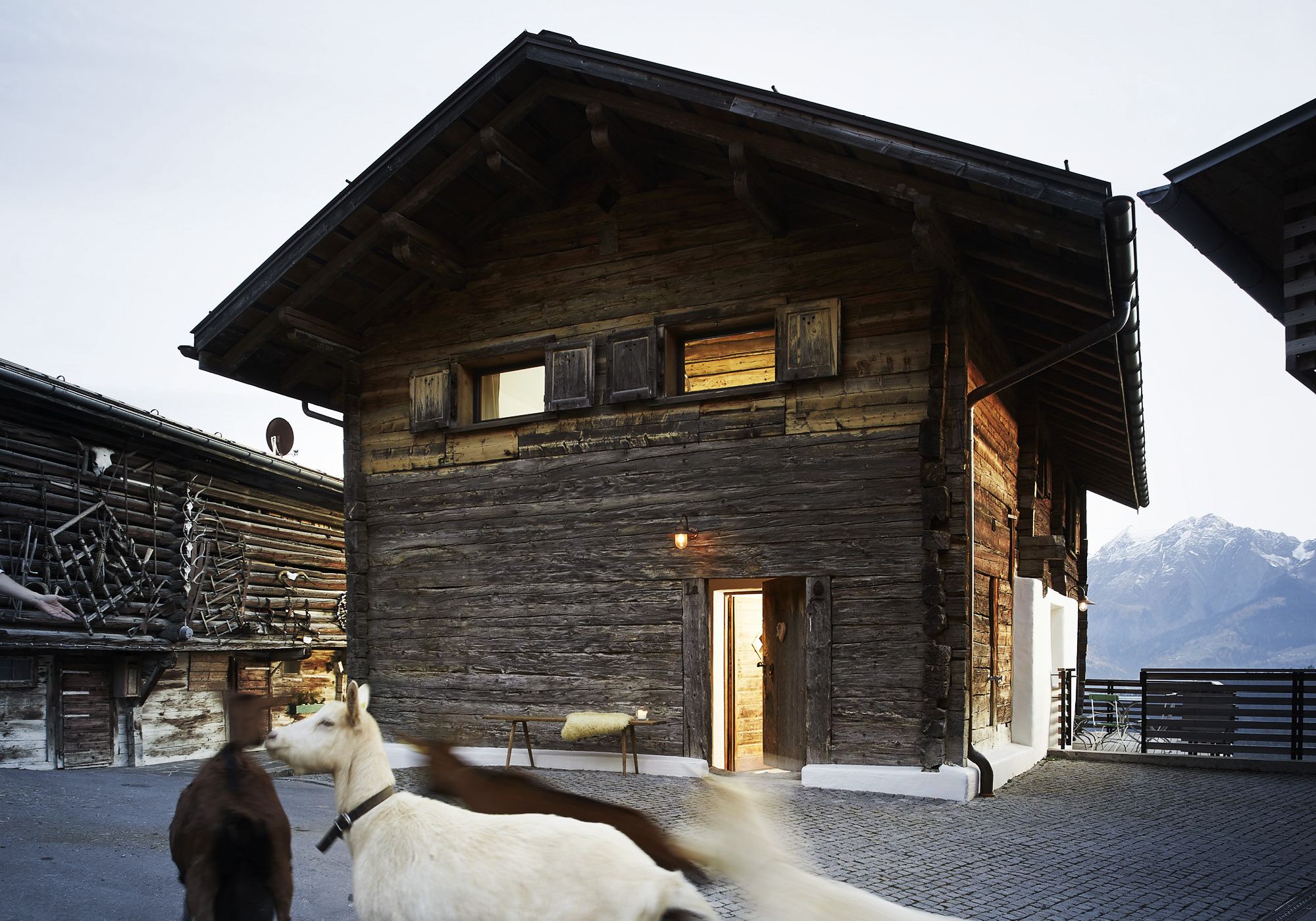 Historic timber house with goats by the entrance – Historic conversion in Fidaz