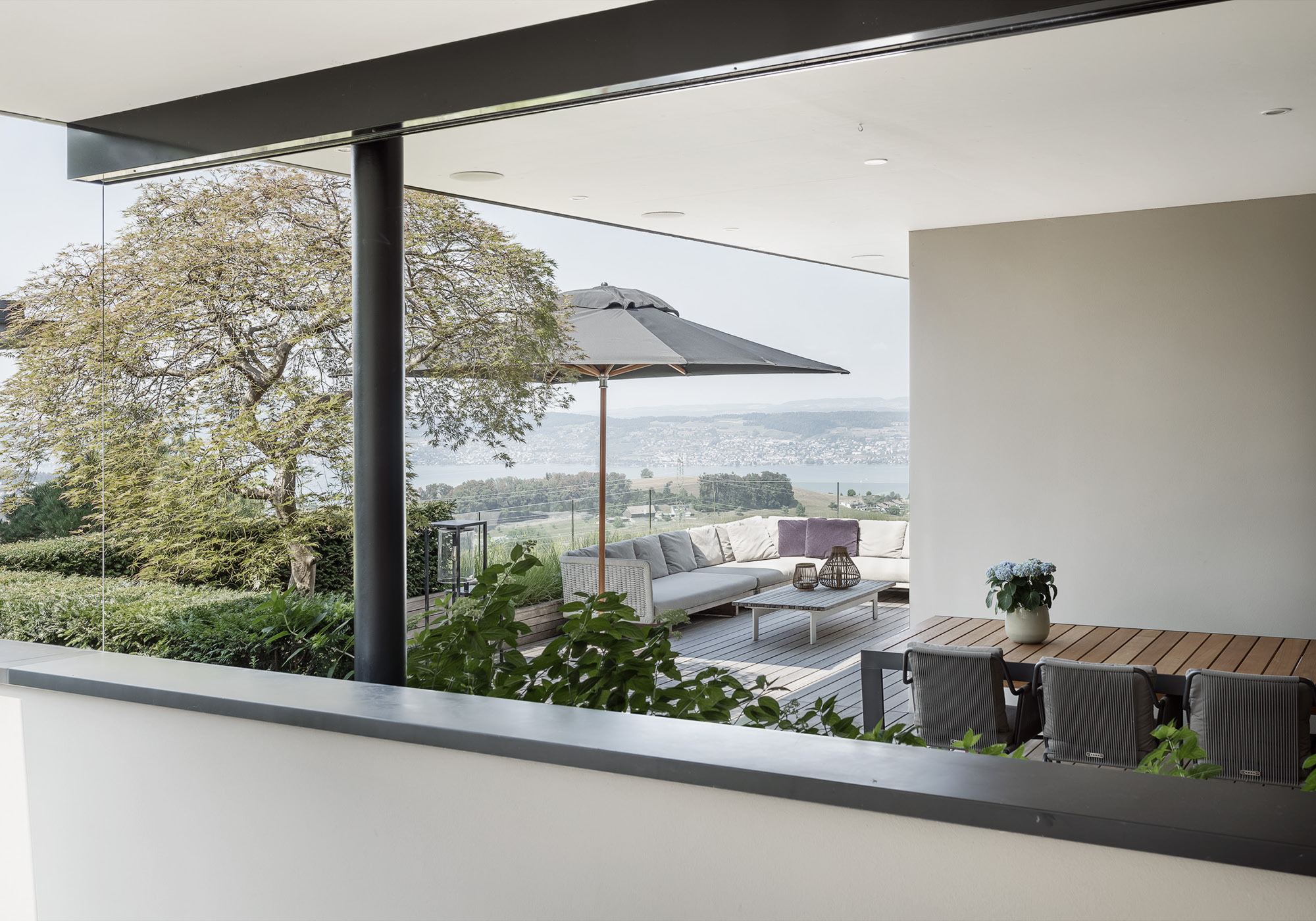 Covered terrace with parasol and view – Single-family house in Schindellegi
