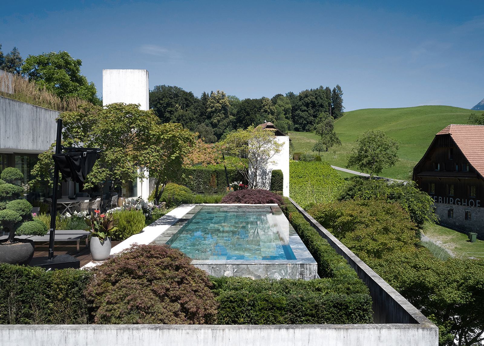 Long pool in the garden with rolling hills