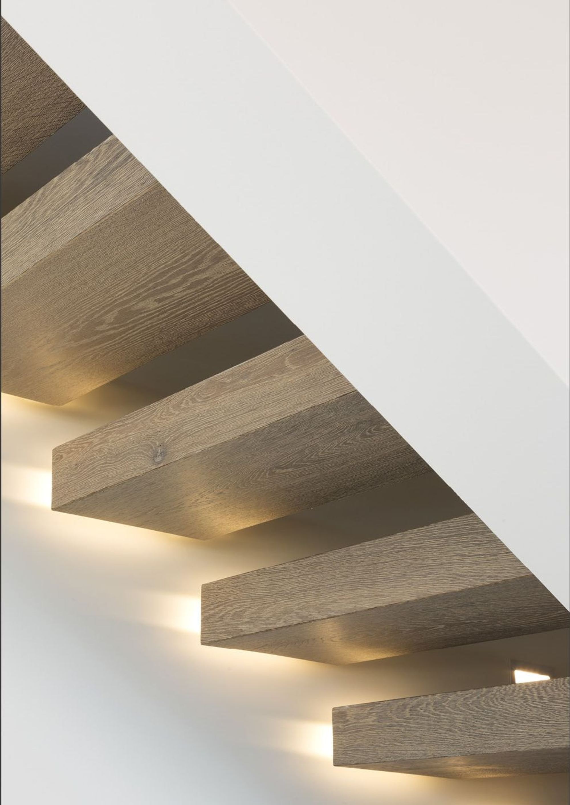 Illuminated timber treads of the cantilevered stair – Single-family house in Wollerau