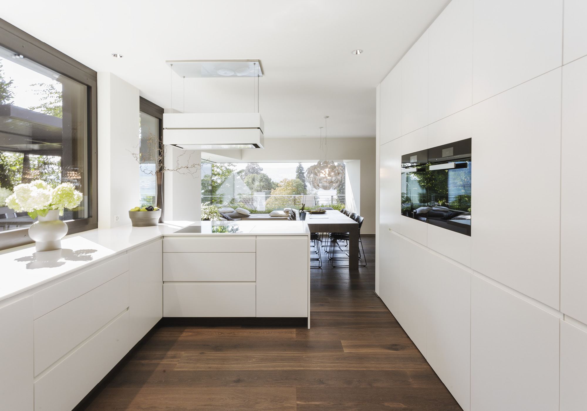 White kitchen with window front and dining table – Single-family house in Meilen